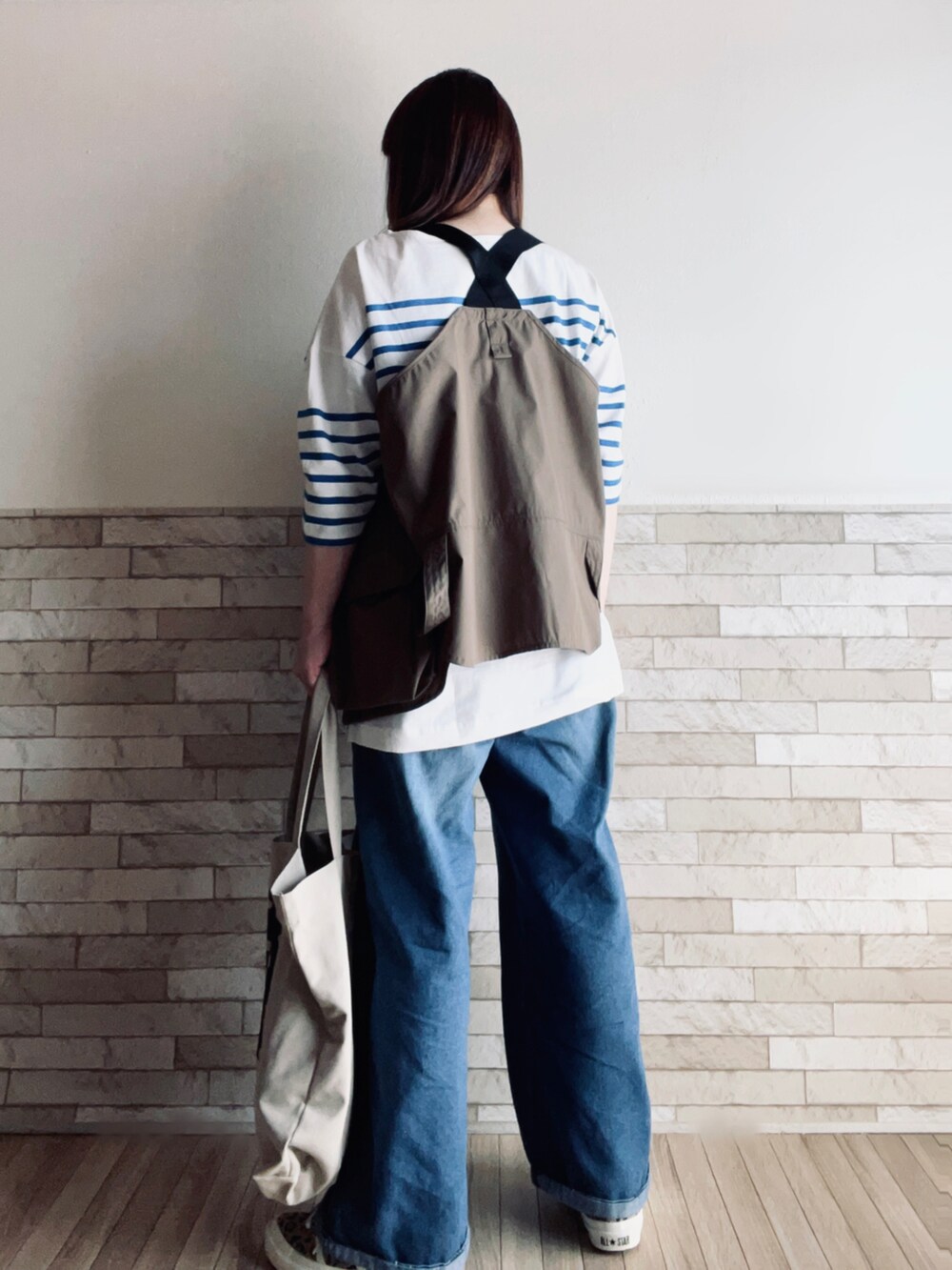 ブルー系のTシャツ/カットソー、その他のベスト、ベージュ系のトートバッグを着用したレディースの春コーディネートの4枚目の写真