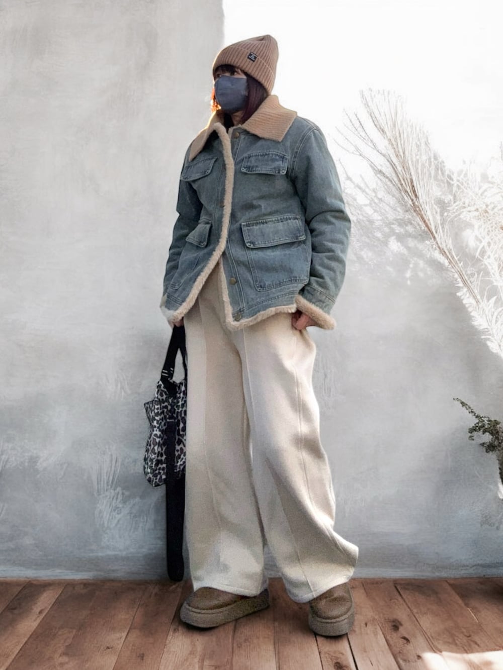 ブラウン系のブーツ、ベージュ系のショルダーバッグ、ブルー系のデニムジャケットを着用したレディースの冬コーディネートの2枚目の写真