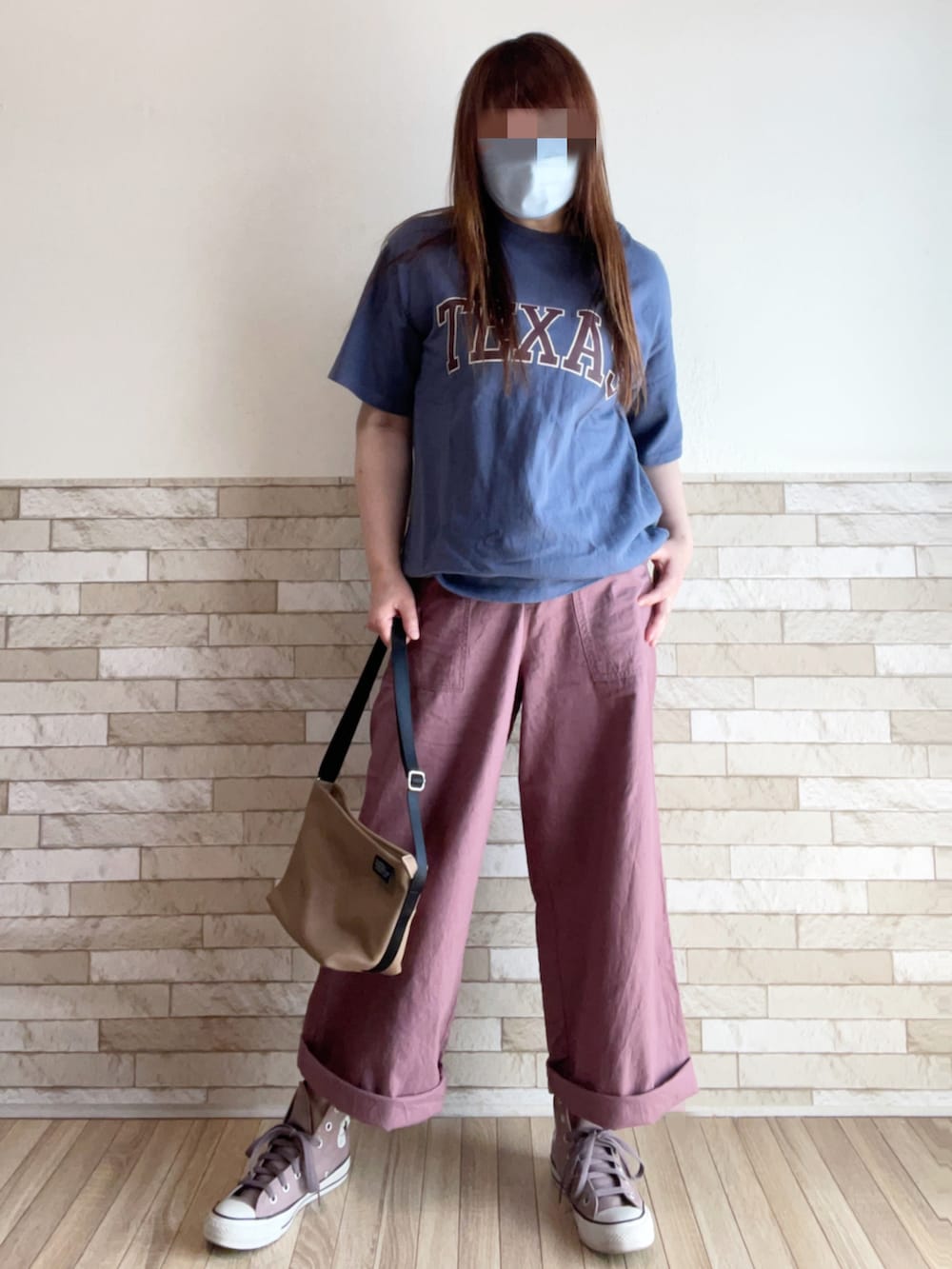 ブルー系のTシャツ/カットソー、ベージュ系のベスト、ブラウン系のスニーカーを着用したレディースの春コーディネートの2枚目の写真