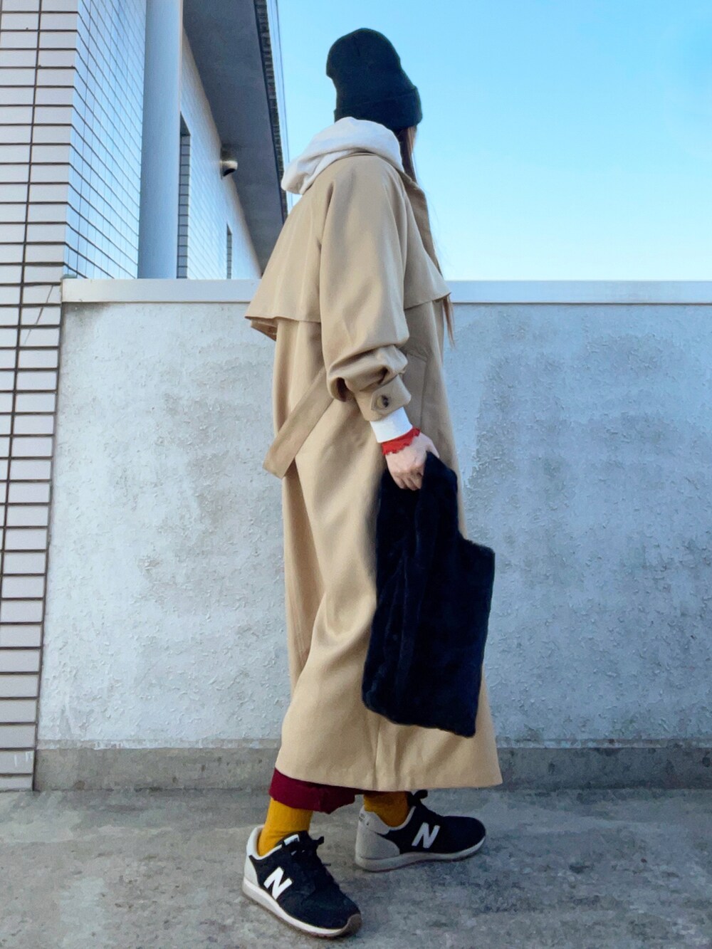 ベージュ系のトレンチコート、オレンジ系のトップス、その他のバッグを着用したレディースの秋コーディネートの5枚目の写真