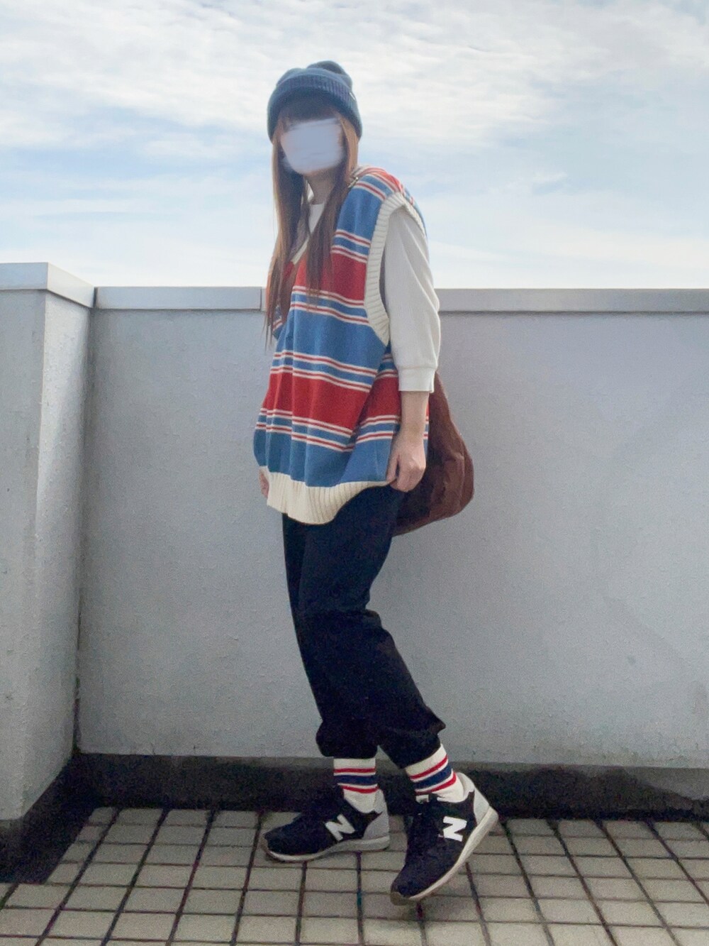 ブルー系のベスト、ホワイト系のTシャツ/カットソー、イエロー系のショルダーバッグを着用したレディースの秋コーディネートの3枚目の写真