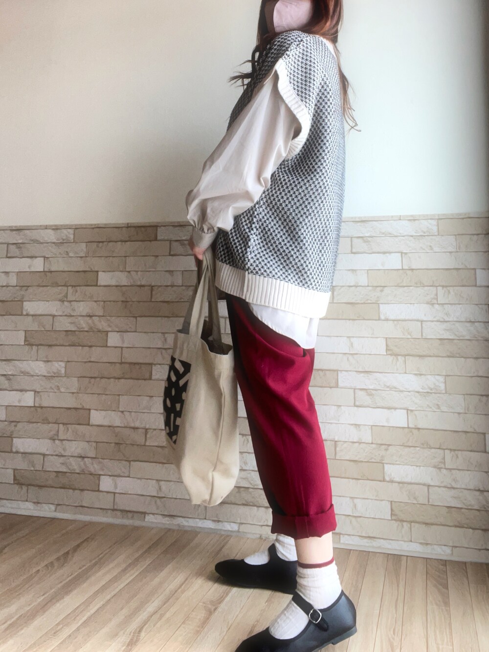 ベージュ系のシャツ/ブラウス、ホワイト系のベスト、レッド系のスラックスを着用したレディースの春コーディネートの4枚目の写真