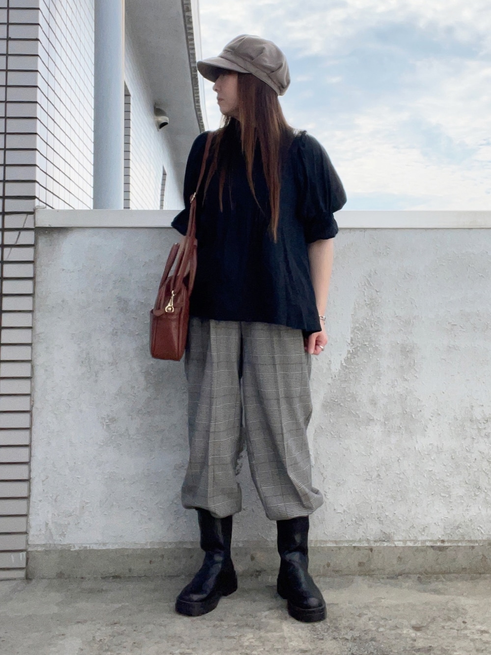 ブラック系のシャツ/ブラウス、ブラウン系のボストンバッグ、グレー系のスラックスを着用したレディースの秋コーディネートの3枚目の写真