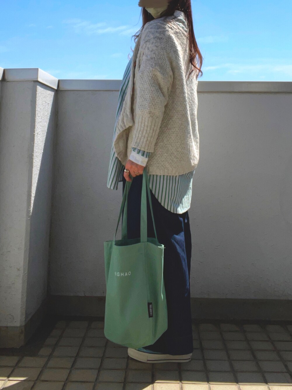 グリーン系のシャツ/ブラウス、グリーン系のトートバッグ、ブルー系のスニーカーを着用したレディースの春コーディネートの3枚目の写真