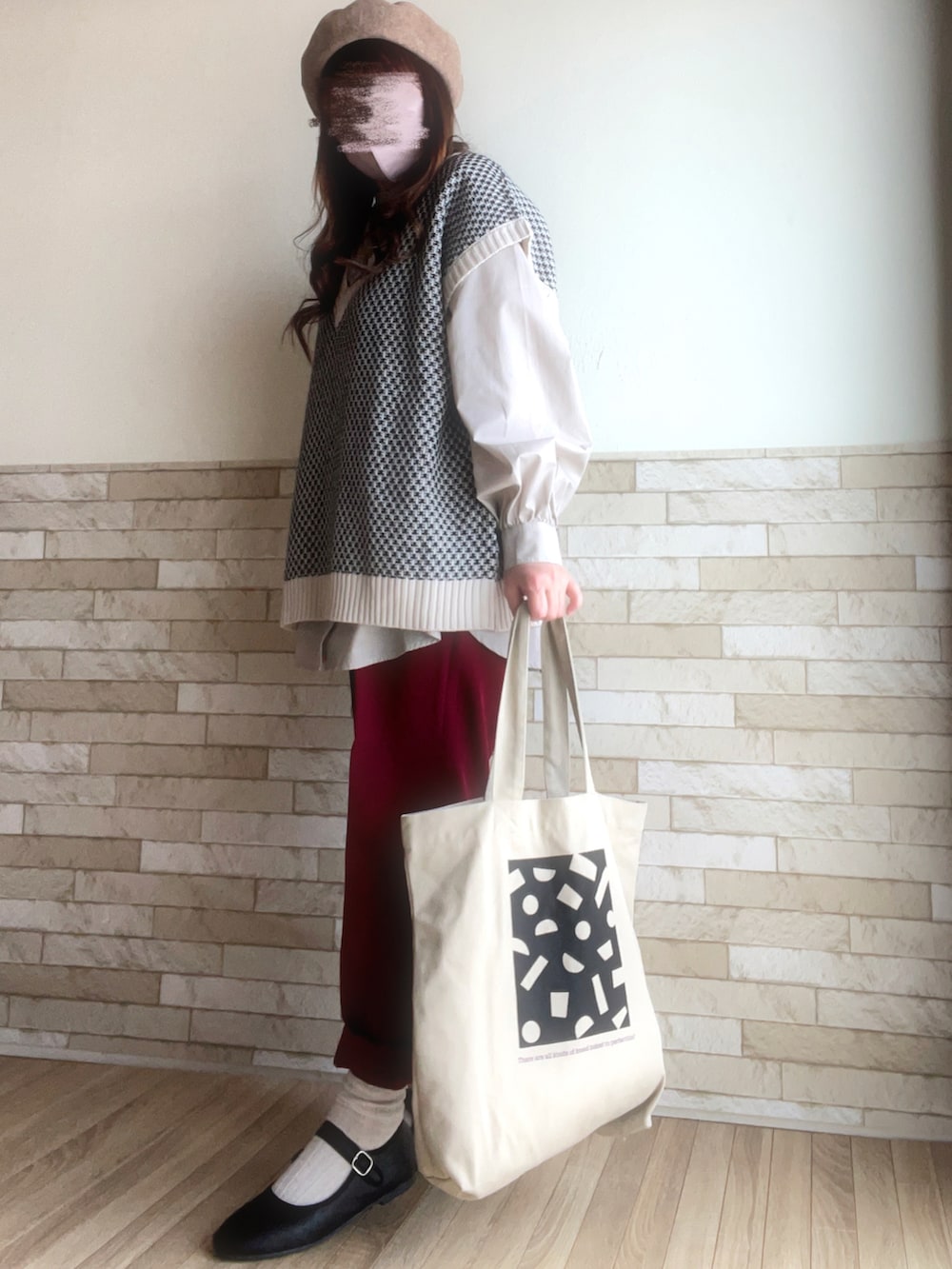 ベージュ系のシャツ/ブラウス、ホワイト系のベスト、レッド系のスラックスを着用したレディースの春コーディネートの2枚目の写真