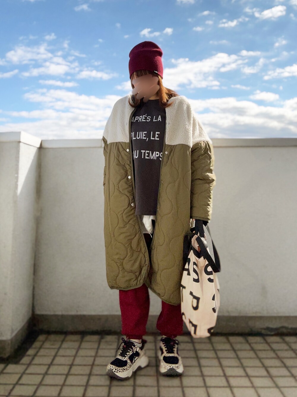 グリーン系のダウンジャケット/コート、レッド系のその他パンツ、その他のスニーカーを着用したレディースの冬コーディネートの2枚目の写真
