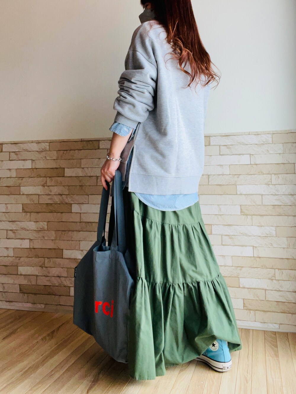 グレー系のスウェット、ブルー系のシャツ/ブラウス、グリーン系のスカートを着用したレディースの春コーディネートの4枚目の写真