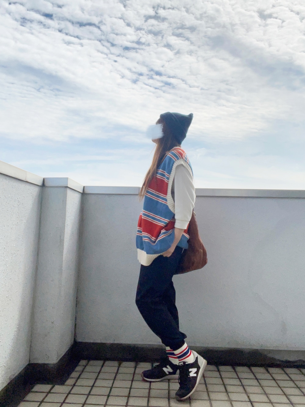 ブルー系のベスト、ホワイト系のTシャツ/カットソー、イエロー系のショルダーバッグを着用したレディースの秋コーディネートの4枚目の写真