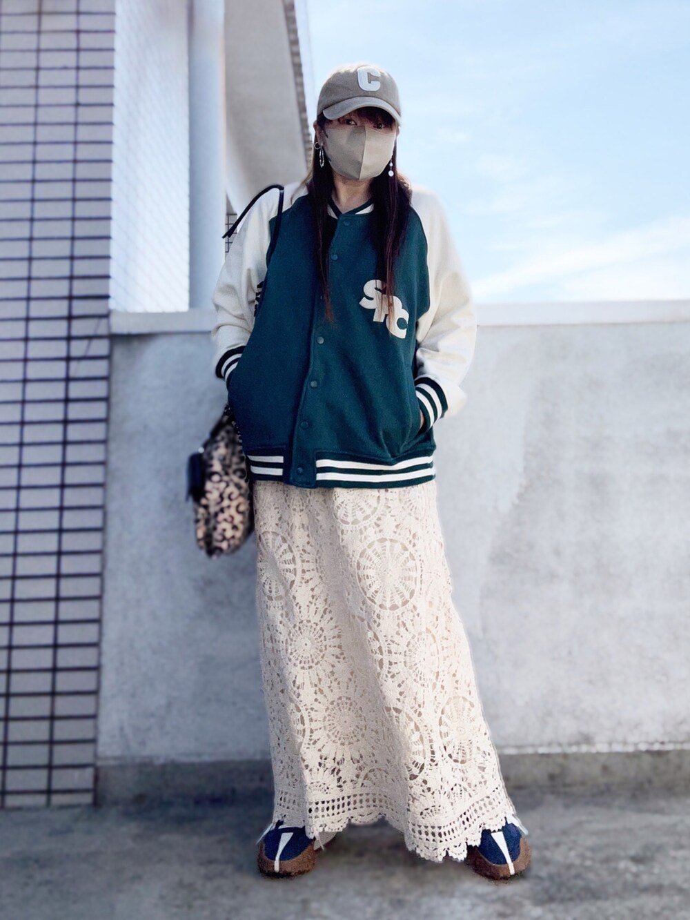 ホワイト系のスカート、ブルー系のスニーカー、その他のトートバッグを着用したレディースの春コーディネートの2枚目の写真