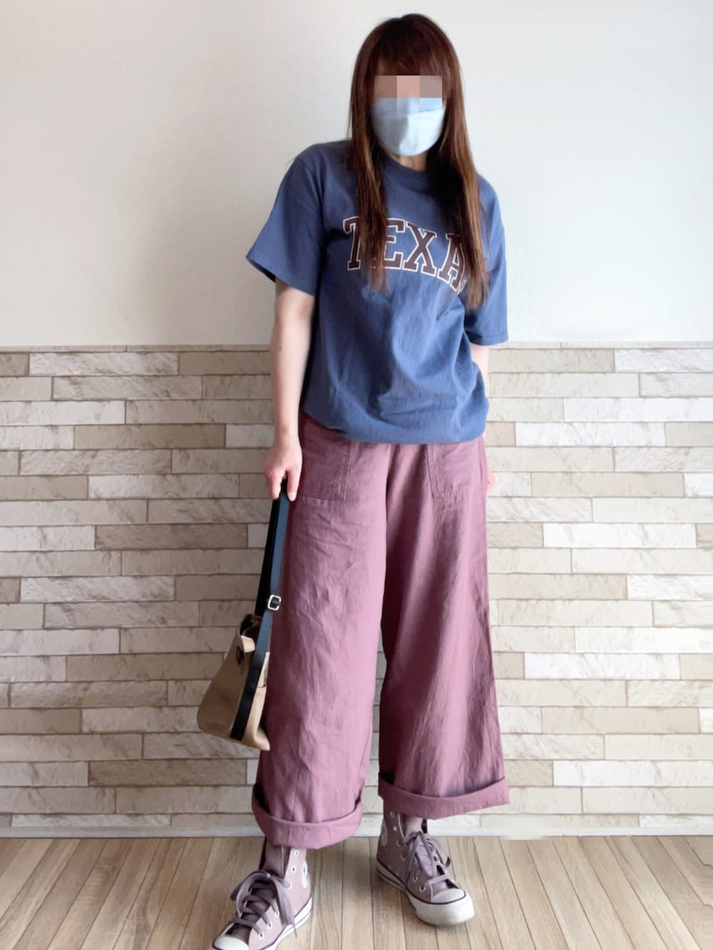 ブルー系のTシャツ/カットソー、ベージュ系のベスト、ブラウン系のスニーカーを着用したレディースの春コーディネートの3枚目の写真