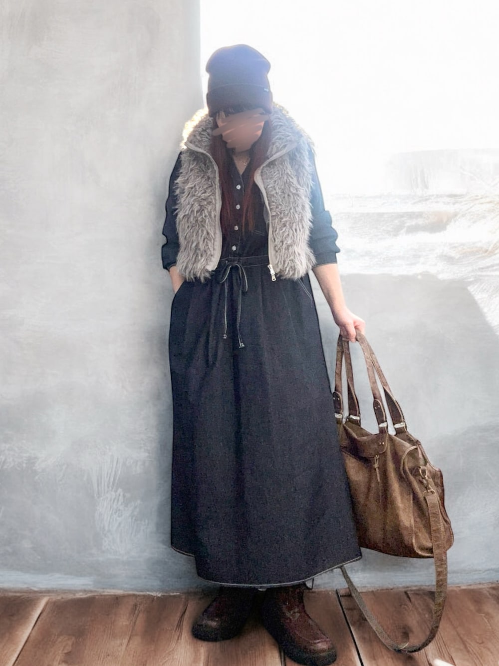 ブラウン系のベスト、ブラック系のワンピース、ブラウン系のバッグを着用したレディースの秋コーディネートの2枚目の写真