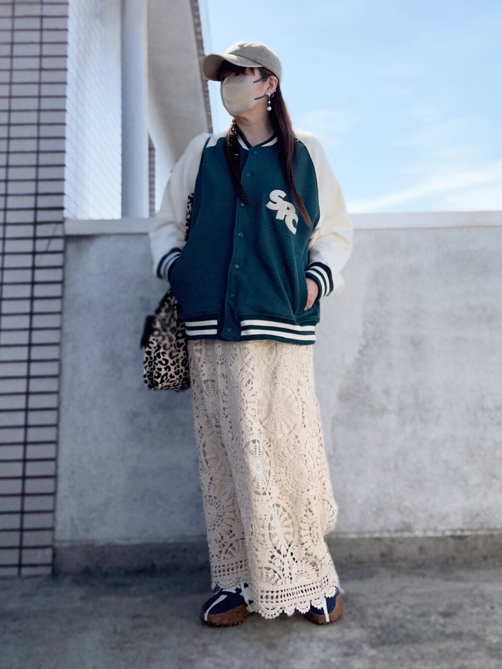 ホワイト系のスカート、ブルー系のスニーカー、その他のトートバッグを着用したレディースの春コーディネートの3枚目の写真