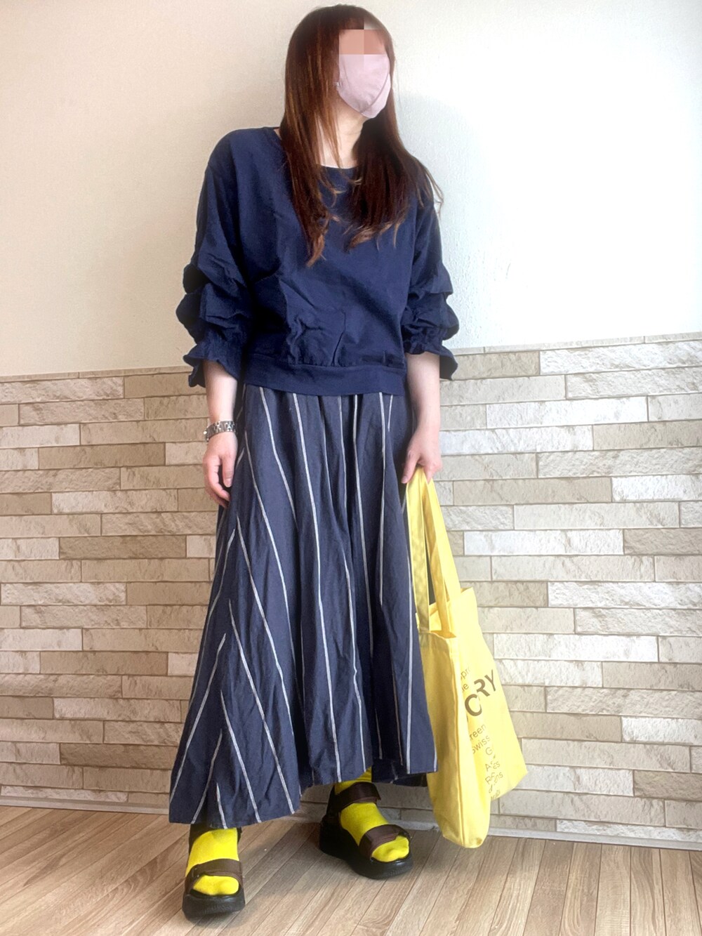 ブルー系のTシャツ/カットソー、イエロー系のトートバッグ、ブラウン系のサンダルを着用したレディースの春コーディネートの3枚目の写真