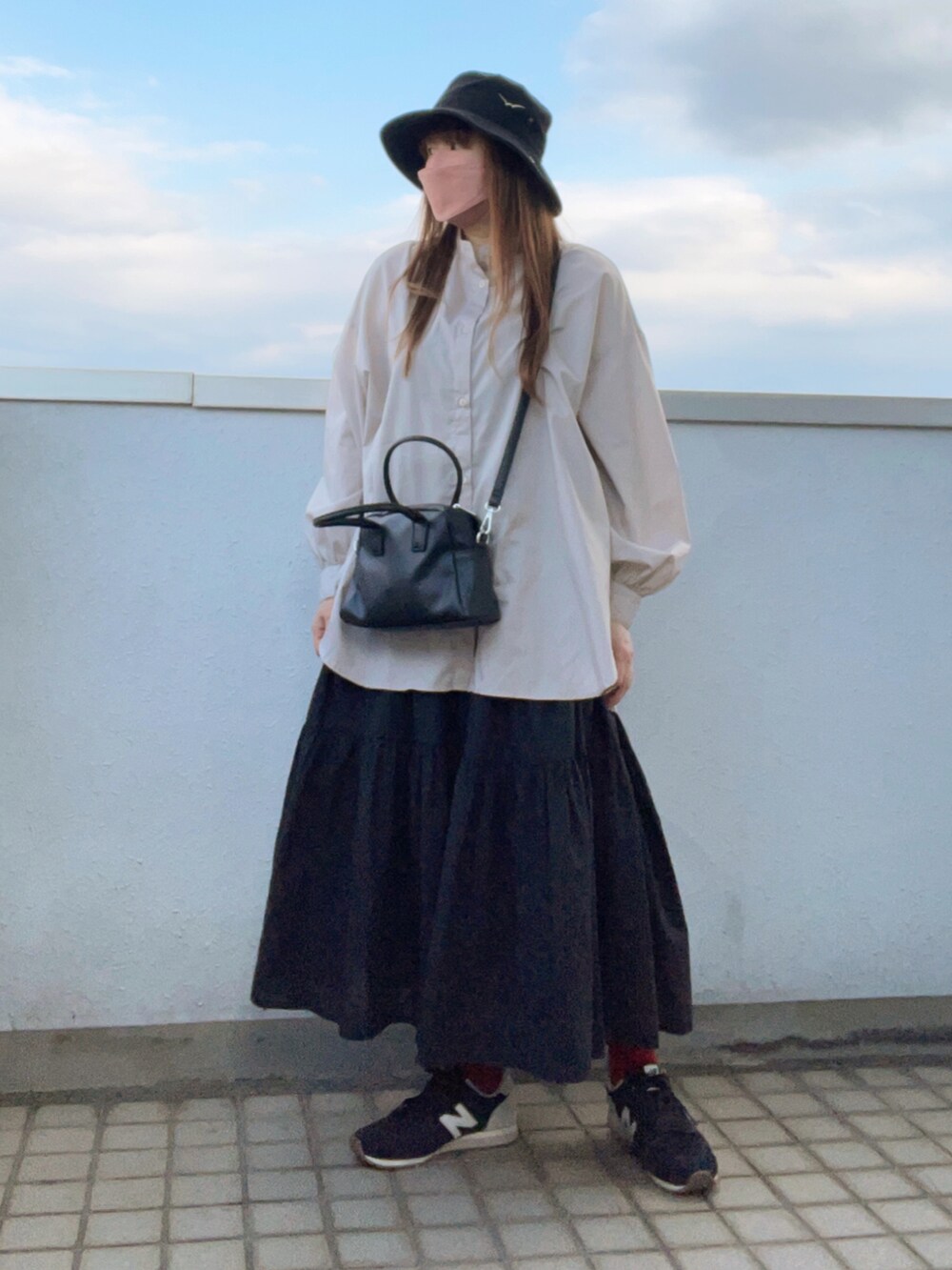 ベージュ系のシャツ/ブラウス、ブラック系のボストンバッグ、ブラック系のスカートを着用したレディースの夏コーディネートの2枚目の写真