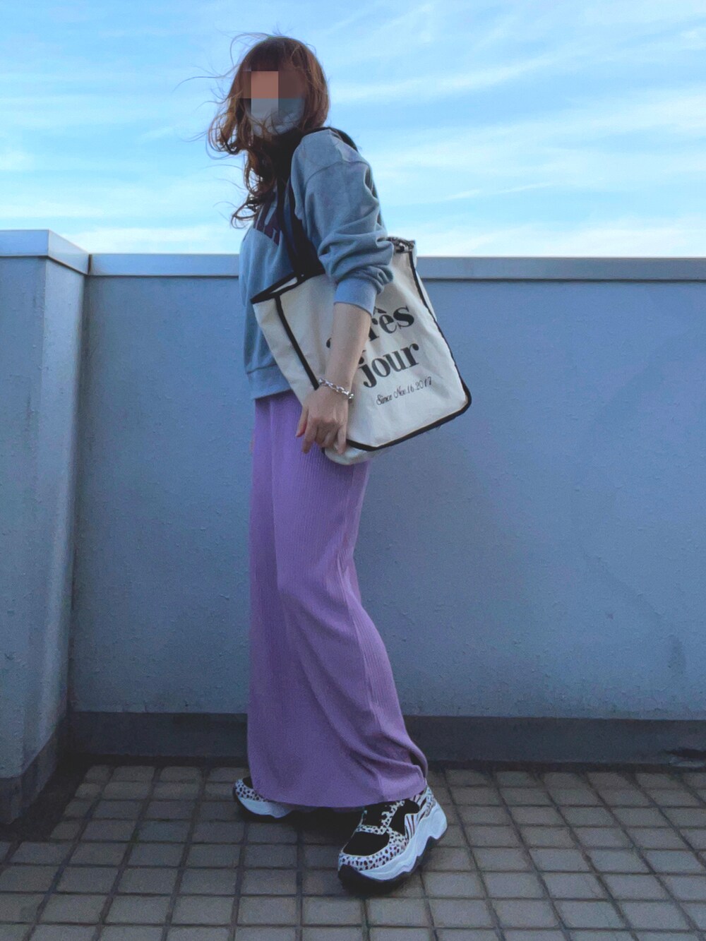 グレー系のスウェット、ピンク系のスカート、その他のスニーカーを着用したレディースの春コーディネートの2枚目の写真