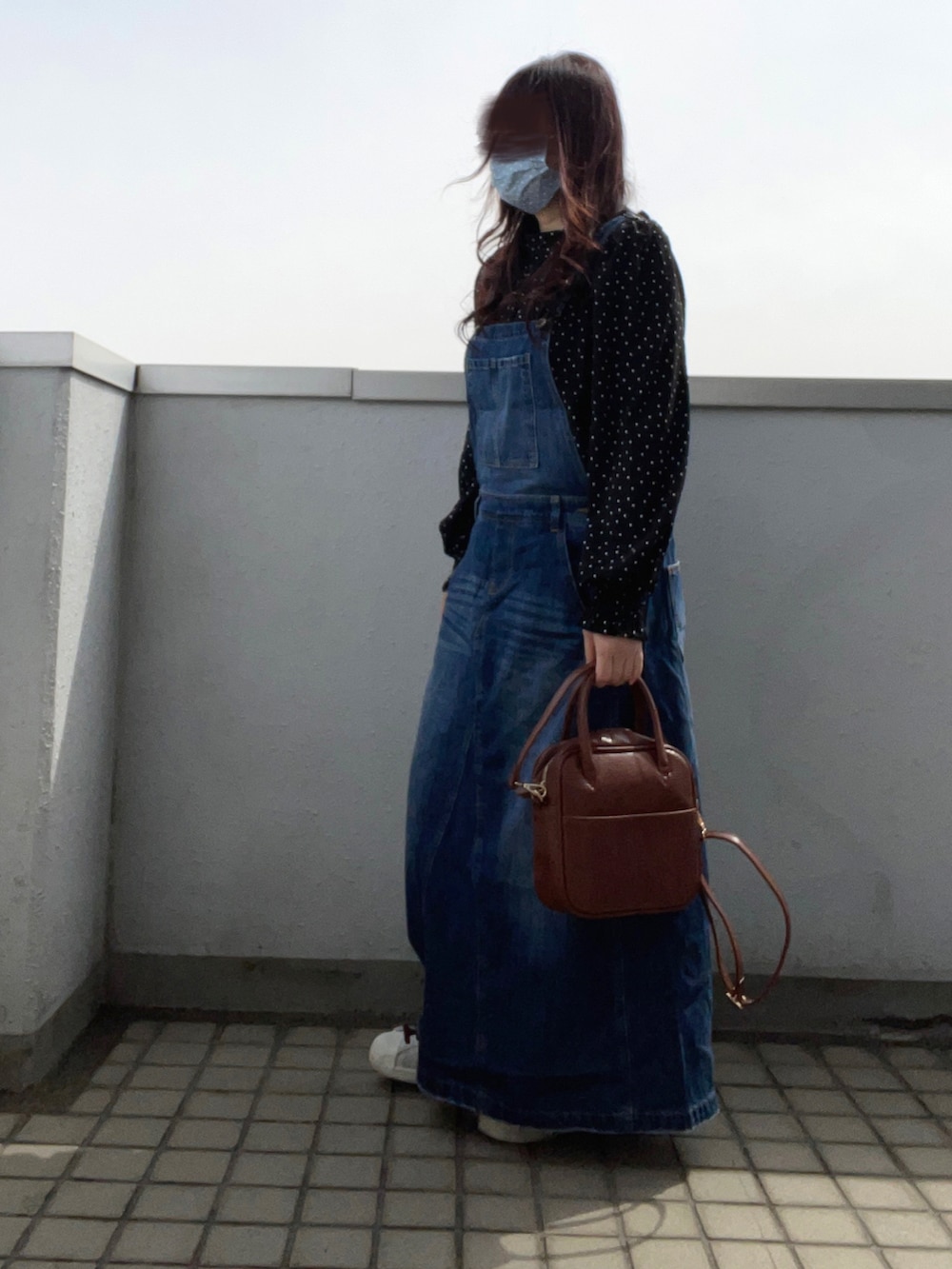 ブラック系のシャツ/ブラウス、ブルー系のサロペット/オーバーオール、ブラウン系のボストンバッグを着用したレディースの春コーディネートの3枚目の写真