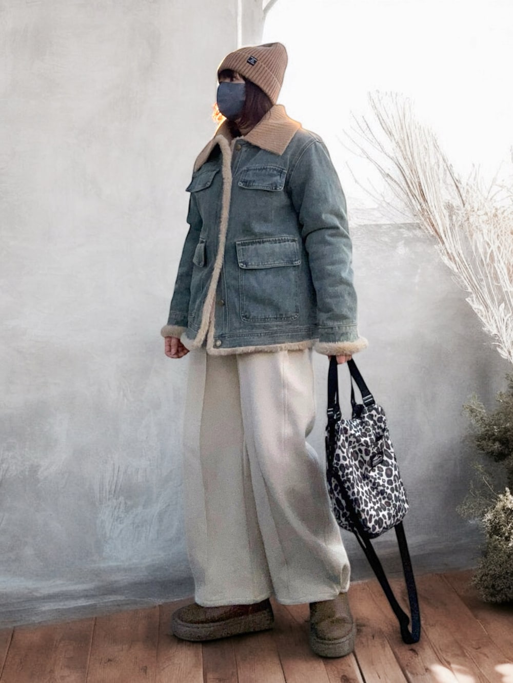 ブラウン系のブーツ、ベージュ系のショルダーバッグ、ブルー系のデニムジャケットを着用したレディースの冬コーディネートの3枚目の写真