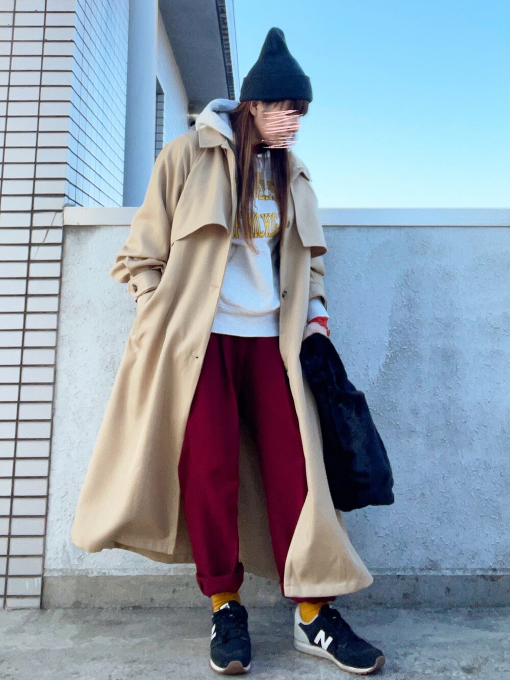 ベージュ系のトレンチコート、オレンジ系のトップス、その他のバッグを着用したレディースの秋コーディネートの4枚目の写真