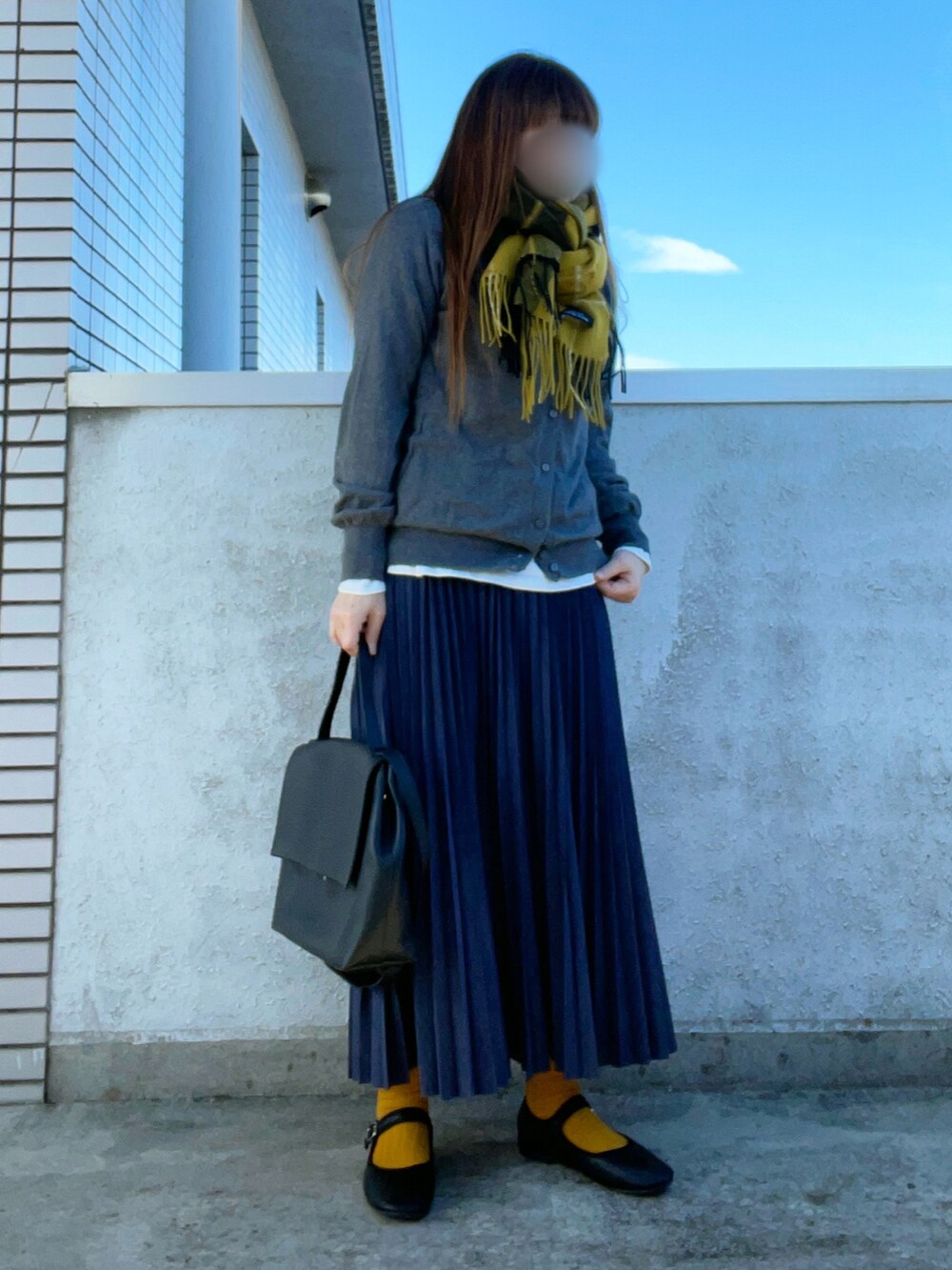 グレー系のカーディガン/ボレロ、ブラック系のショルダーバッグ、ブルー系のスカートを着用したレディースの秋コーディネートの2枚目の写真