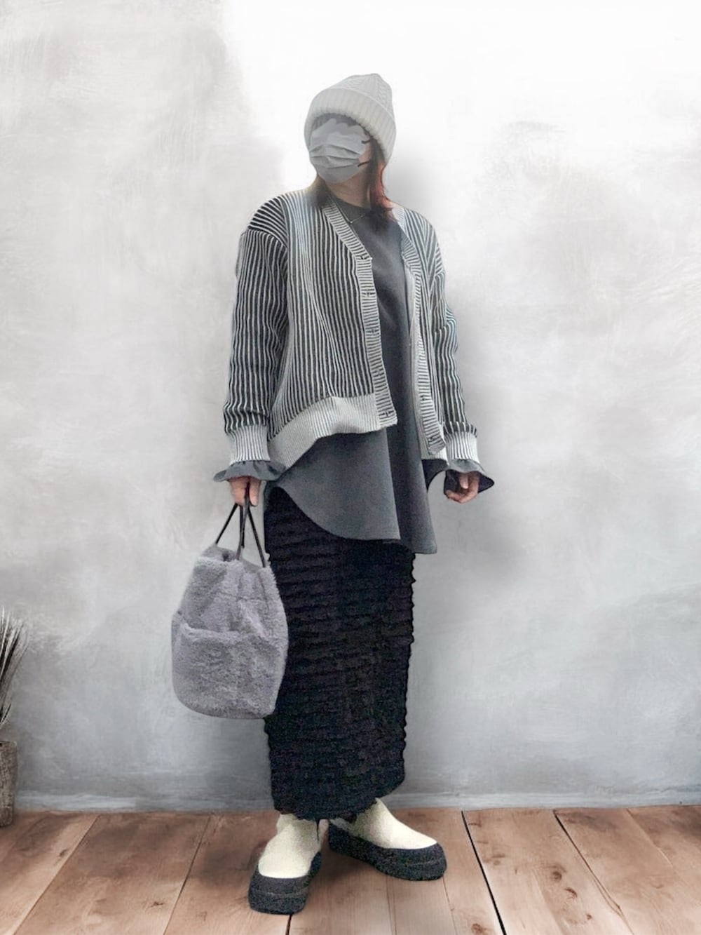 ホワイト系のブーツ、ブラック系のスカート、ブラック系のカーディガン/ボレロを着用したレディースの冬コーディネートの2枚目の写真