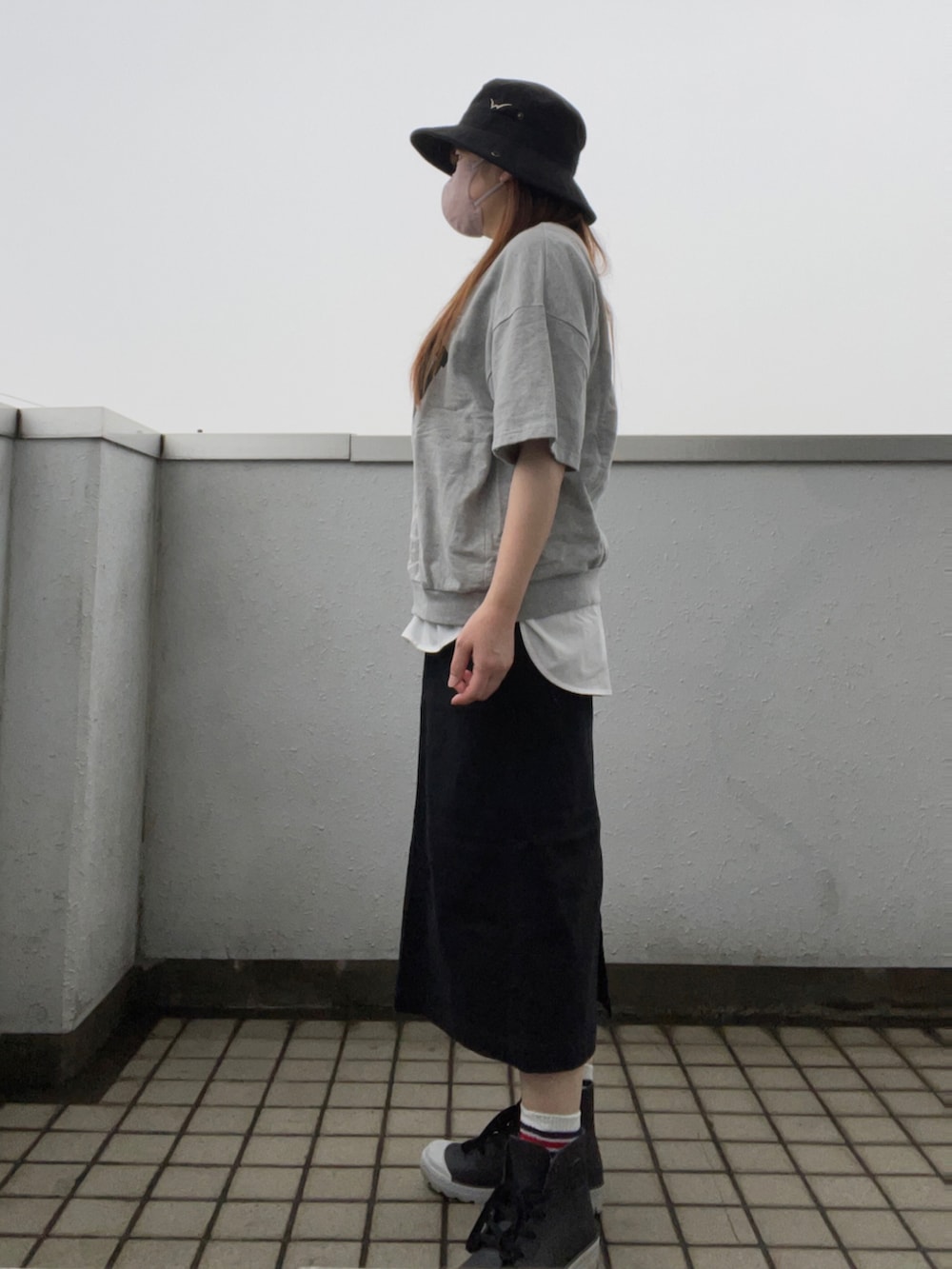 グレー系のTシャツ/カットソー、ブラック系のスカート、ブラック系の帽子を着用したレディースの夏コーディネートの3枚目の写真