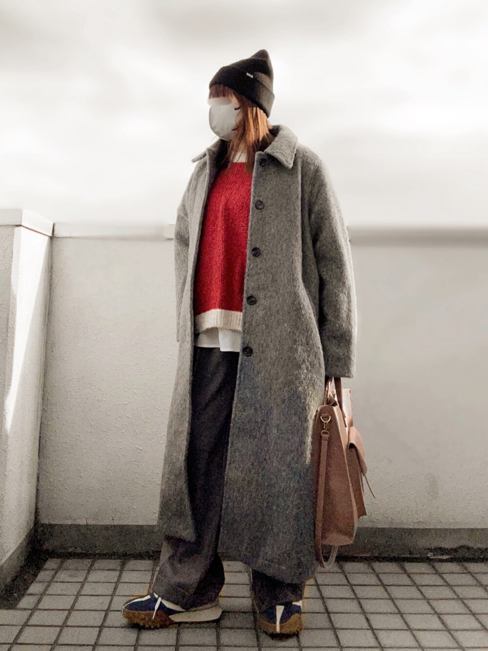 レッド系のニット/セーター、グレー系のパンツ、ブルー系のスニーカーを着用したレディースの冬コーディネートの3枚目の写真