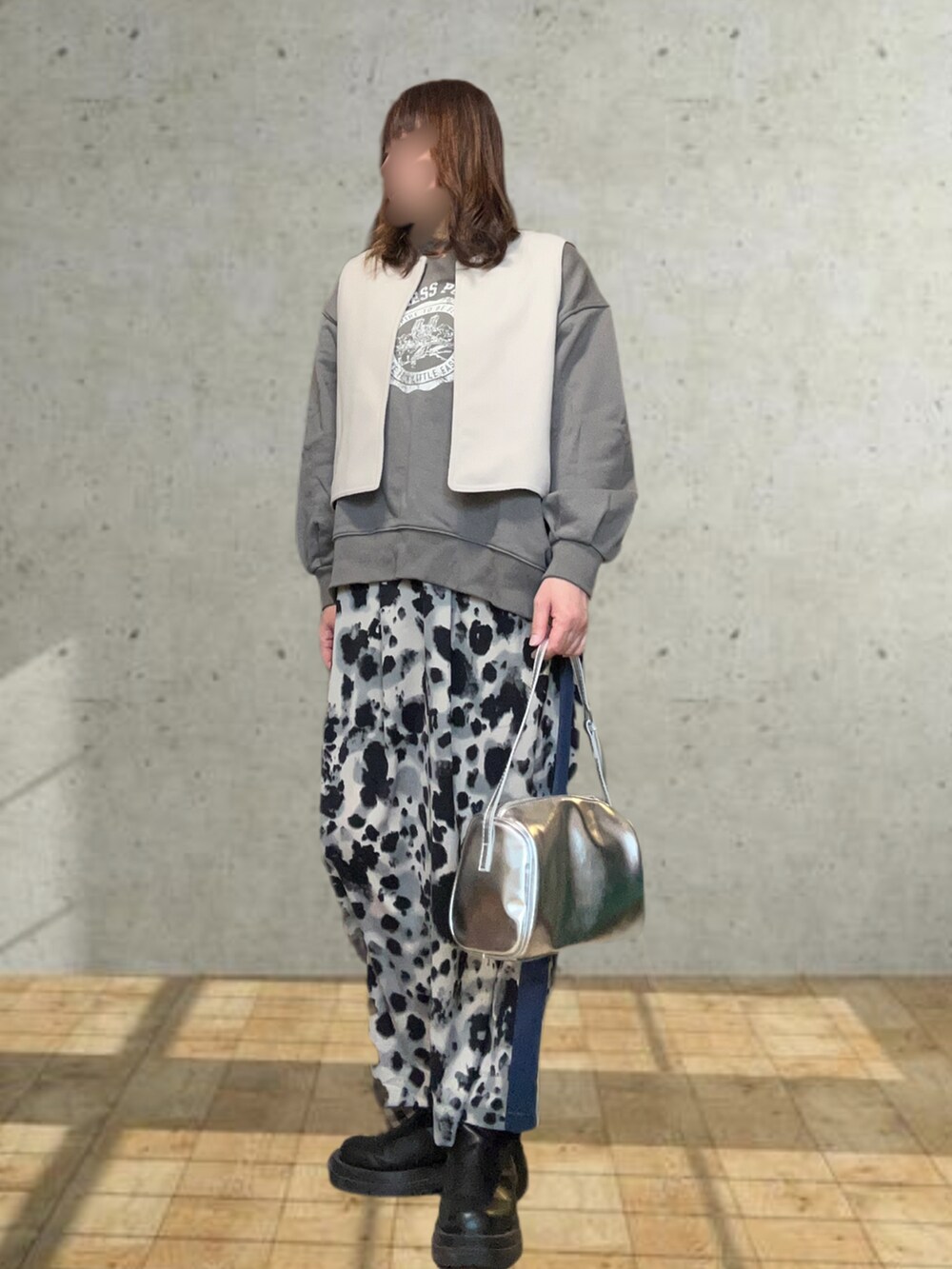 ベージュ系のステンカラーコート、グレー系のスウェット、ブラック系のスカートを着用したレディースの冬コーディネートの3枚目の写真