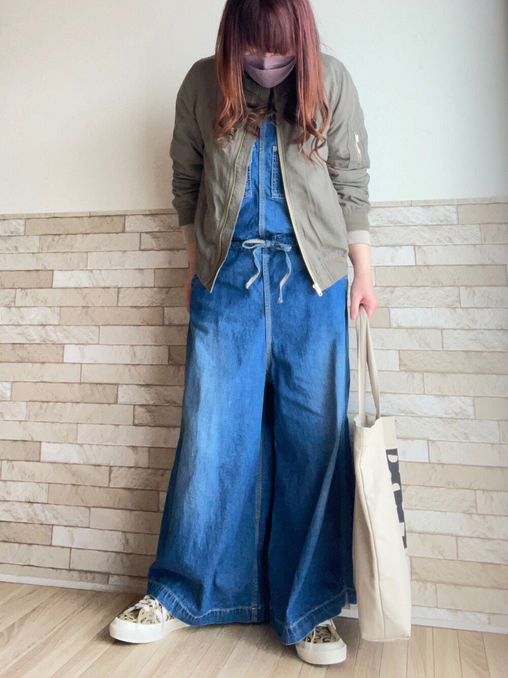 グリーン系のMA-1、ブルー系のサロペット/オーバーオール、ベージュ系のトートバッグを着用したレディースの春コーディネートの2枚目の写真