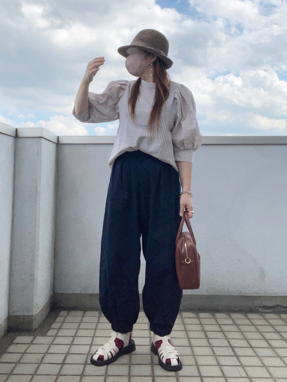 ベージュ系のシャツ/ブラウス、ブルー系のデニムパンツ、ブラウン系のボストンバッグを着用したレディースの秋コーディネートの2枚目の写真