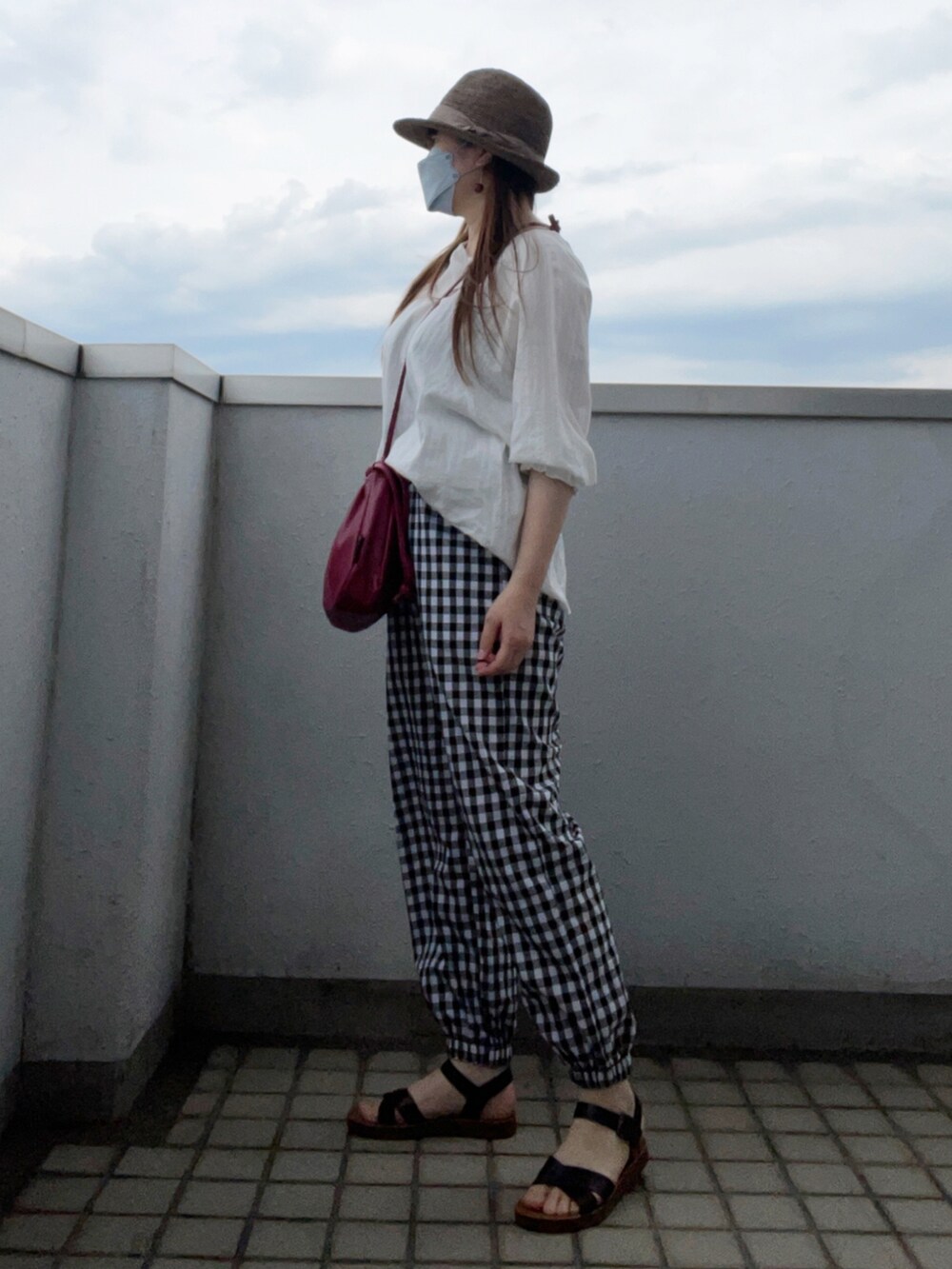 ホワイト系のシャツ/ブラウス、ブラック系のパンツ、ブラック系のサンダルを着用したレディースの夏コーディネートの3枚目の写真