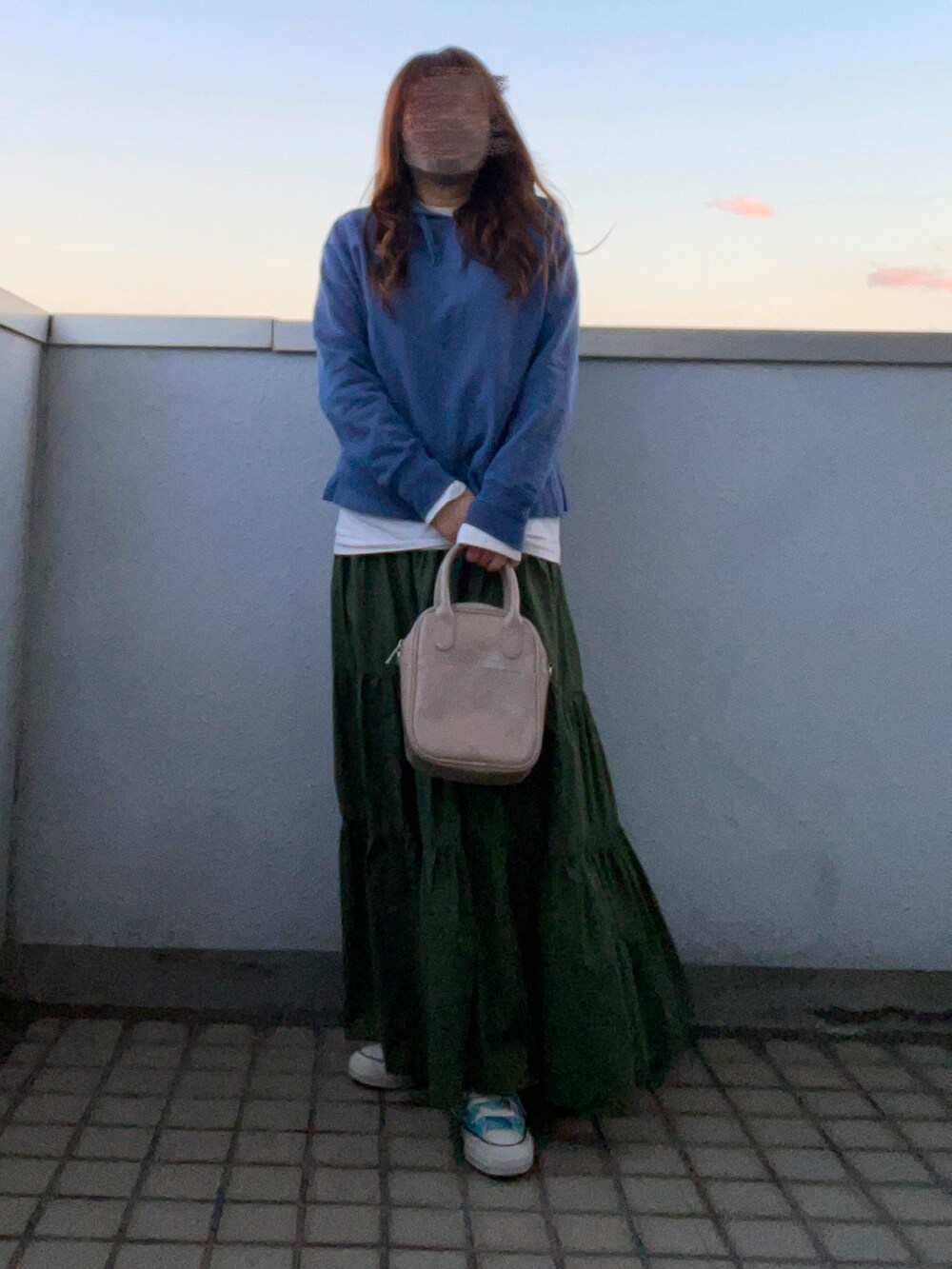 ブルー系のパーカー、グリーン系のスカート、ベージュ系のハンドバッグを着用したレディースの冬コーディネートの2枚目の写真