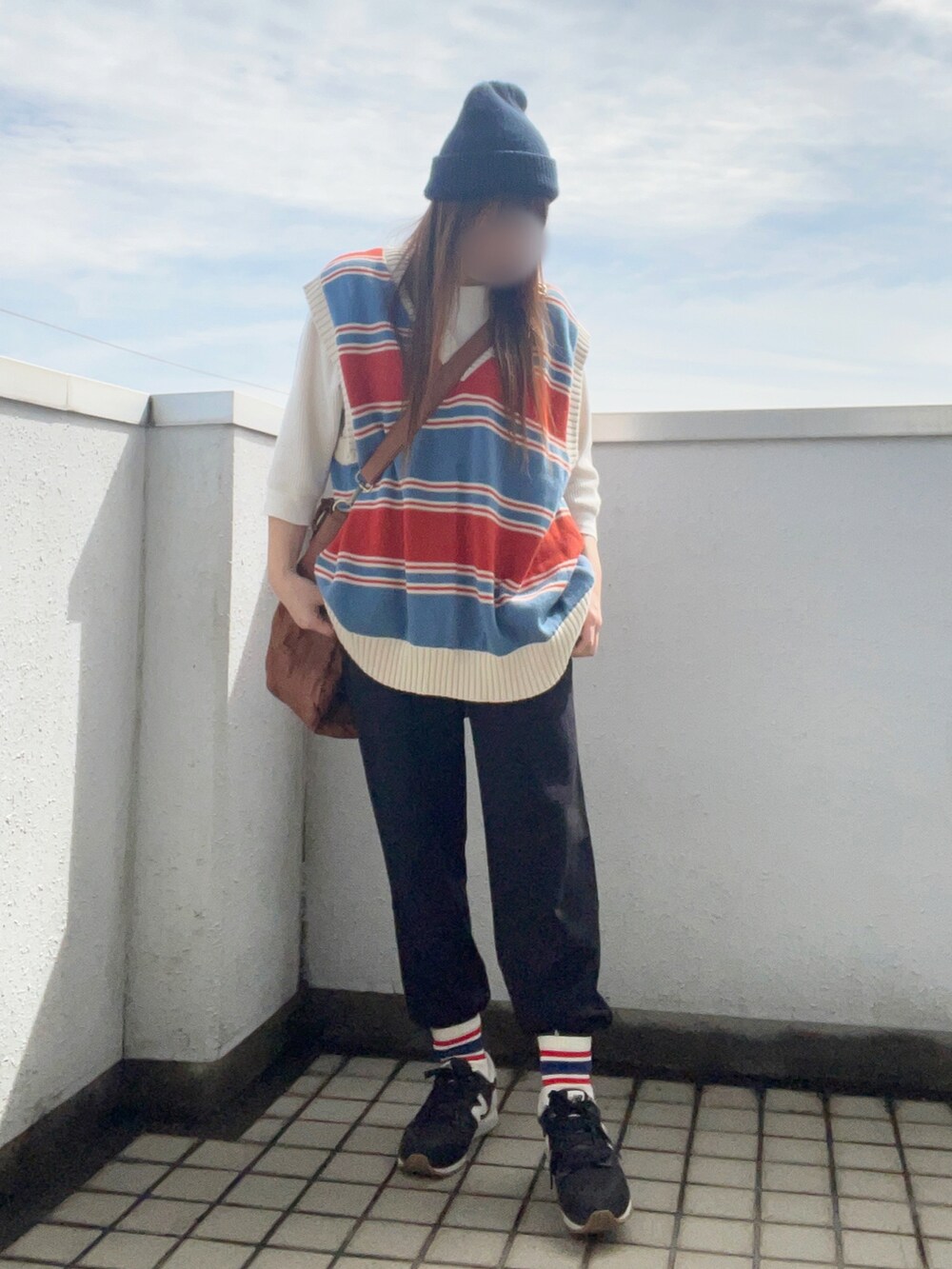 ブルー系のベスト、ホワイト系のTシャツ/カットソー、イエロー系のショルダーバッグを着用したレディースの秋コーディネートの2枚目の写真