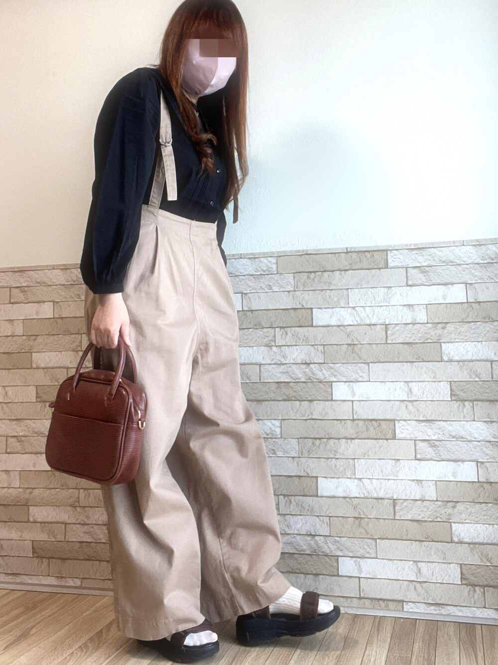 ブラック系のシャツ/ブラウス、ブラウン系のボストンバッグ、ブラウン系のサンダルを着用したレディースの春コーディネートの2枚目の写真