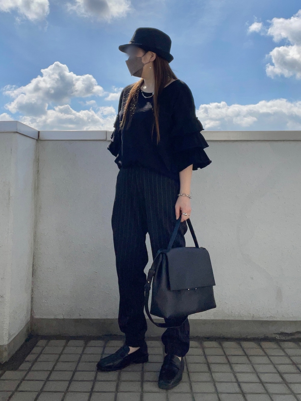 ブラック系のTシャツ/カットソー、ブラック系のショルダーバッグ、ブラック系のローファーを着用したレディースの秋コーディネートの2枚目の写真