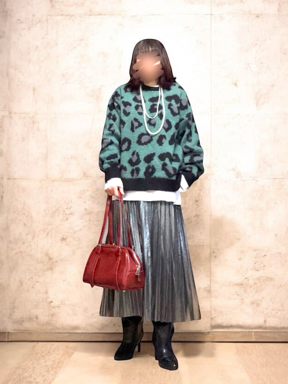 レッド系のボストンバッグ、グリーン系のニット/セーター、ホワイト系のカバーオールを着用したレディースの冬コーディネートの3枚目の写真