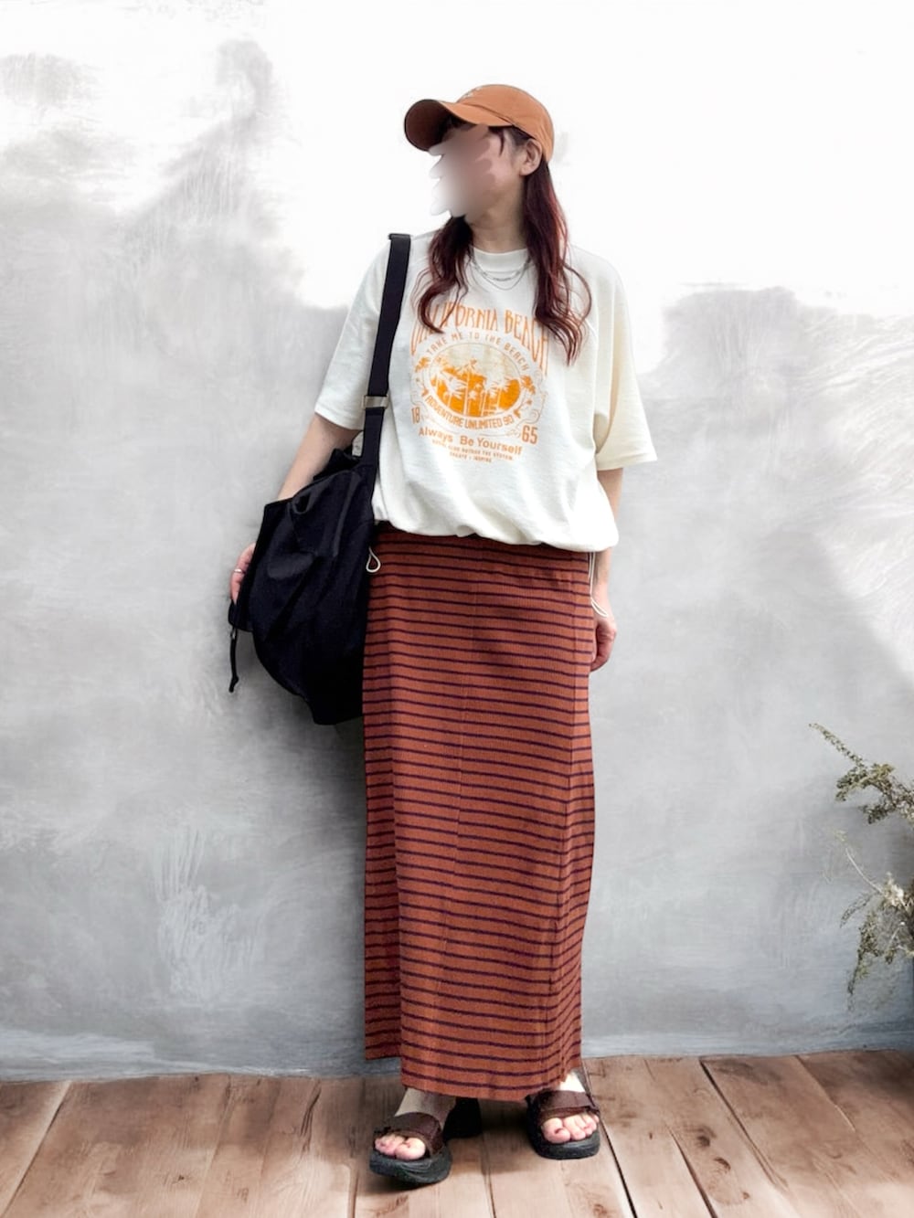 ホワイト系のスウェット、ブラウン系のスカート、ブラック系のバックパック/リュックを着用したレディースの夏コーディネートの2枚目の写真