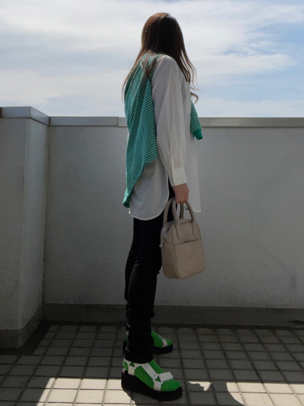 ホワイト系のシャツ/ブラウス、グリーン系のTシャツ/カットソー、ブラック系のパンツを着用したレディースの春コーディネートの4枚目の写真