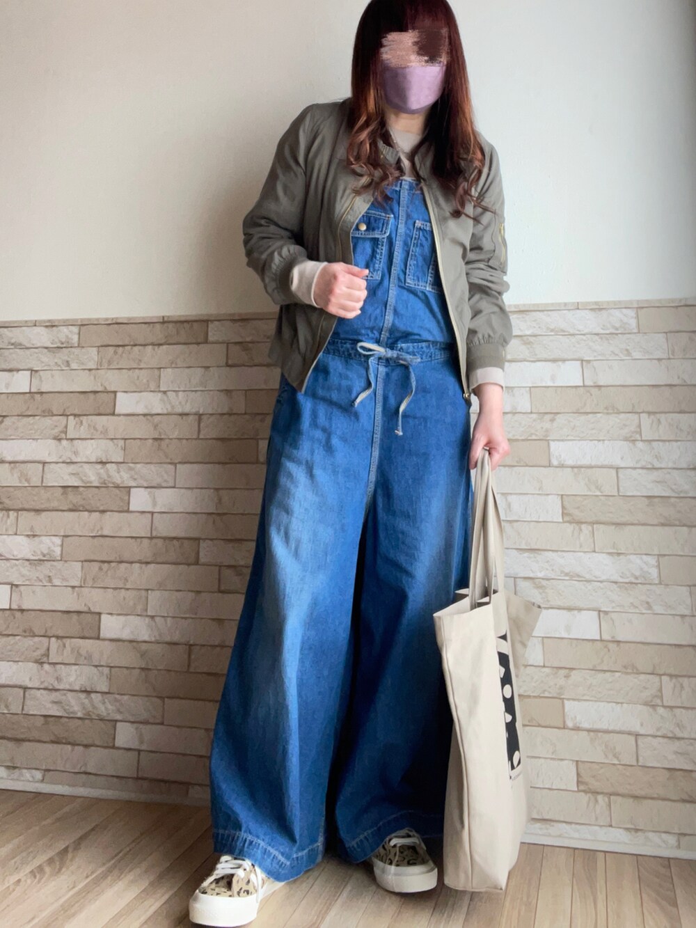 グリーン系のMA-1、ブルー系のサロペット/オーバーオール、ベージュ系のトートバッグを着用したレディースの春コーディネートの3枚目の写真