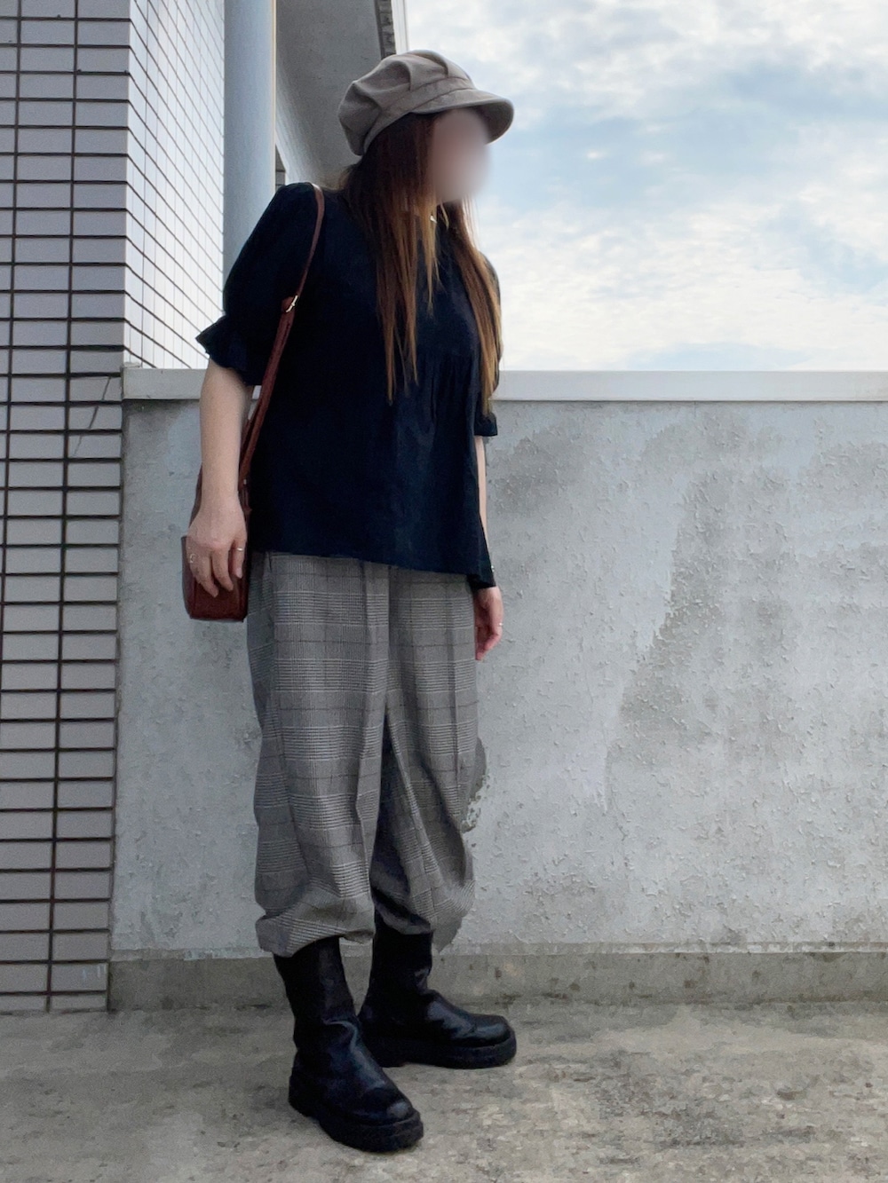 ブラック系のシャツ/ブラウス、ブラウン系のボストンバッグ、グレー系のスラックスを着用したレディースの秋コーディネートの2枚目の写真