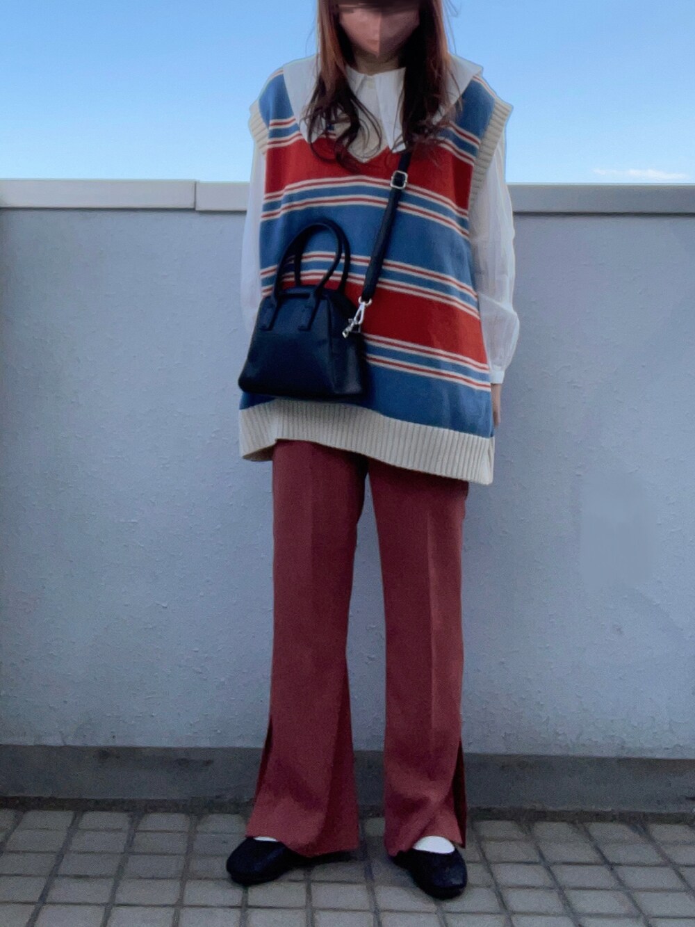 ホワイト系のシャツ/ブラウス、ブルー系のベスト、ブラック系のボストンバッグを着用したレディースの春コーディネートの4枚目の写真