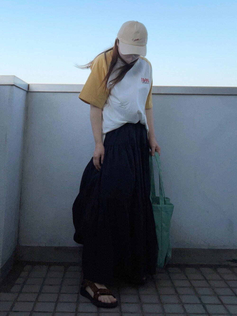 その他のサンダル、イエロー系のTシャツ/カットソー、ブラック系のスカートを着用したレディースの夏コーディネートの2枚目の写真