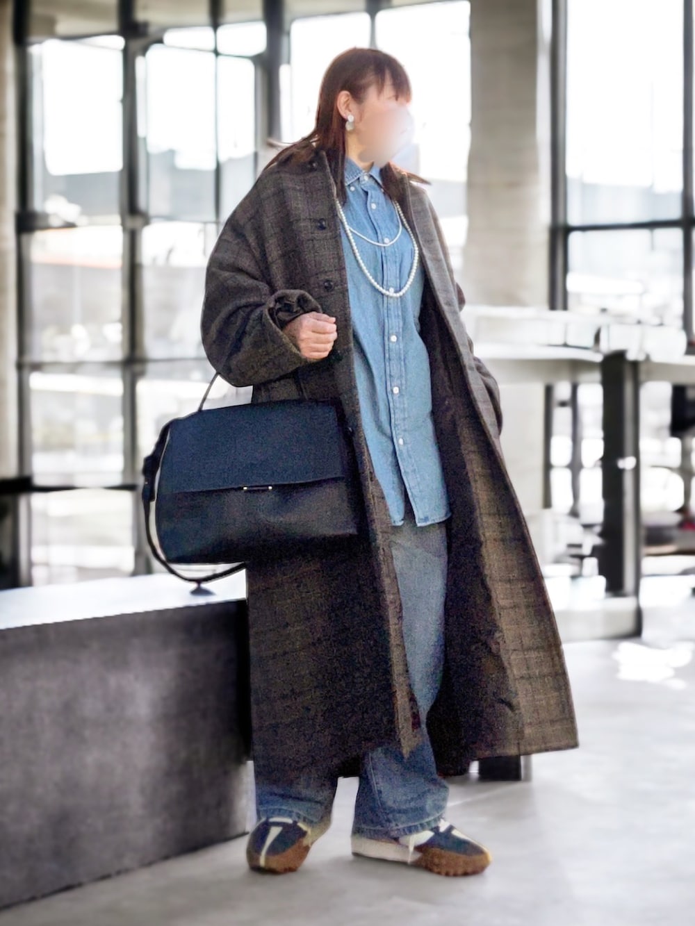 グレー系のステンカラーコート、ブルー系のシャツ/ブラウス、ブラック系のショルダーバッグを着用したレディースの冬コーディネートの2枚目の写真