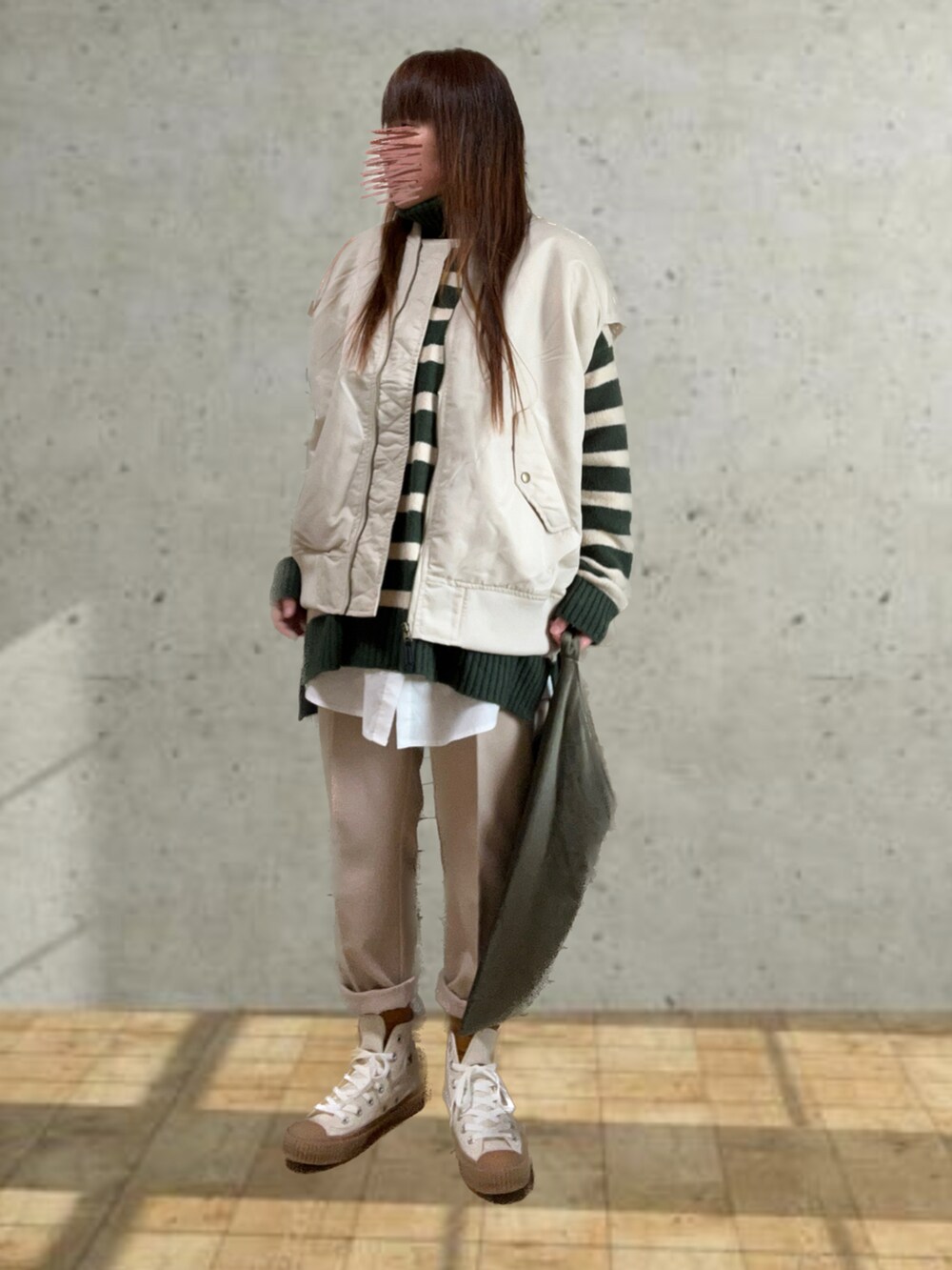 グリーン系のニット/セーター、ホワイト系のスラックス、その他のバッグを着用したレディースの冬コーディネートの2枚目の写真