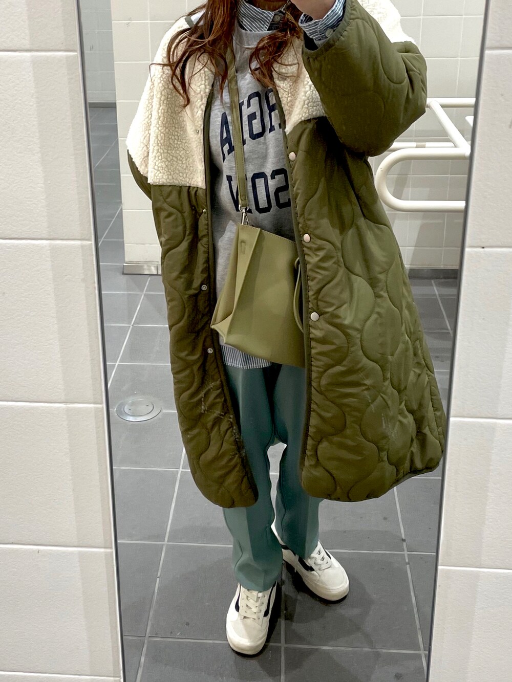 グレー系のスウェット、グリーン系のダウンジャケット/コート、グリーン系のショルダーバッグを着用したレディースの冬コーディネートの3枚目の写真