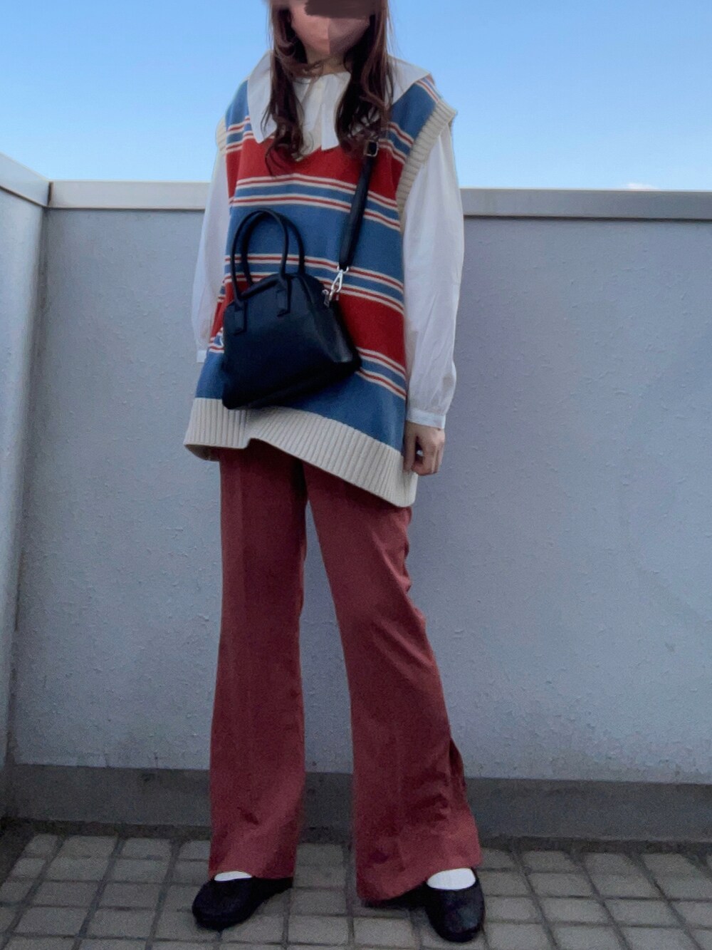 ホワイト系のシャツ/ブラウス、ブルー系のベスト、ブラック系のボストンバッグを着用したレディースの春コーディネートの2枚目の写真