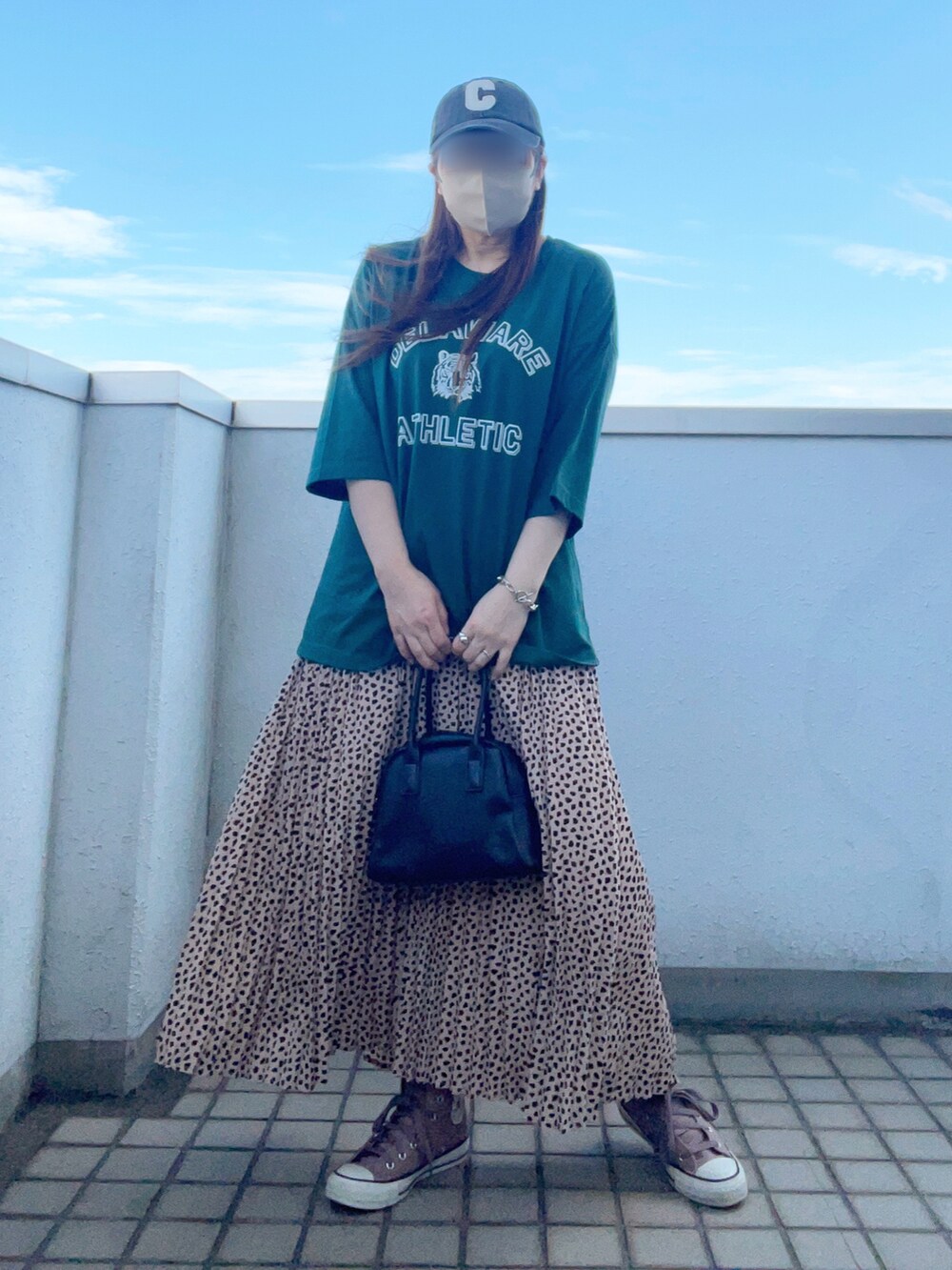 グリーン系のTシャツ/カットソー、ピンク系のスカート、ブラック系のボストンバッグを着用したレディースの夏コーディネートの2枚目の写真