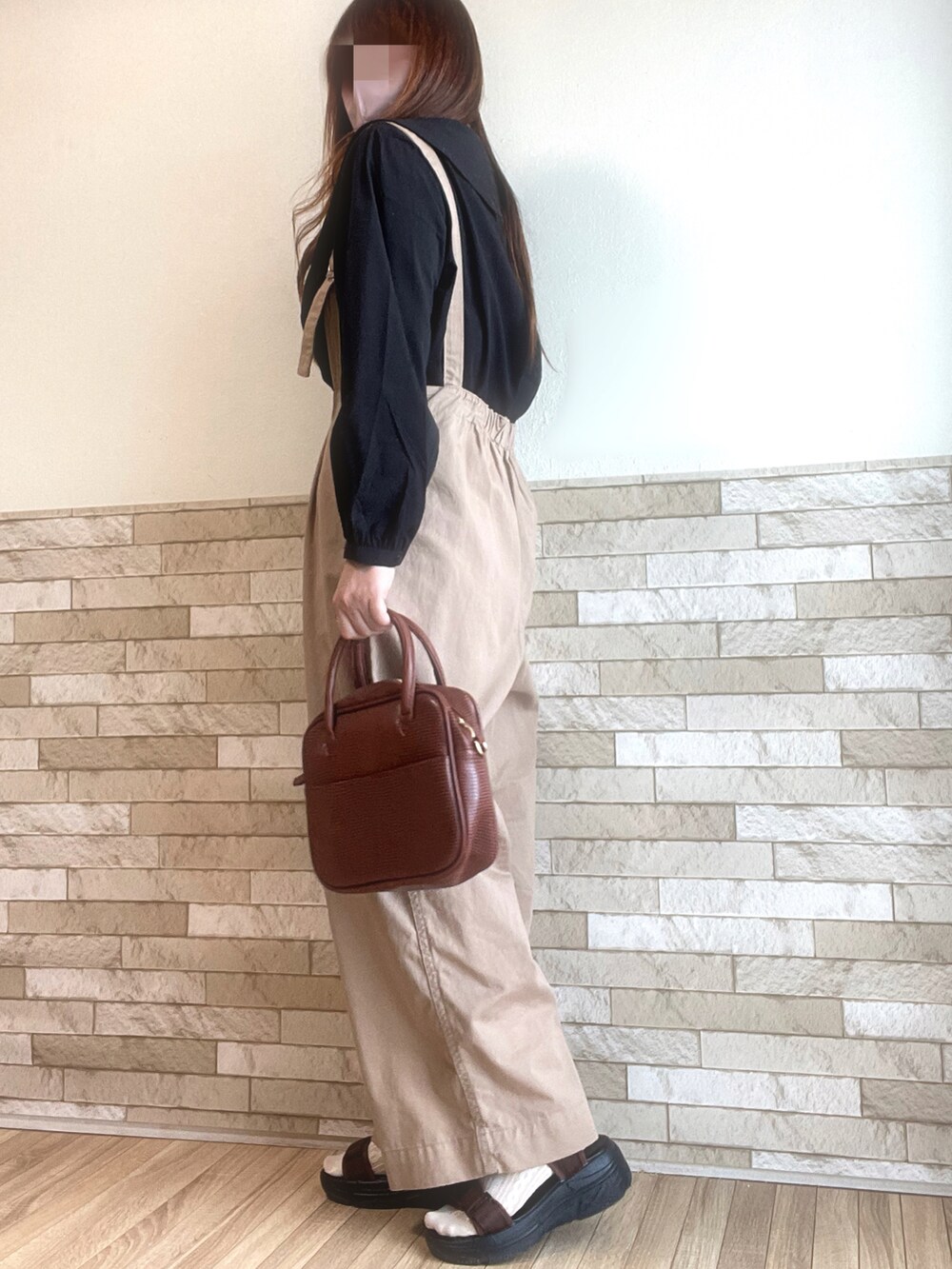 ブラック系のシャツ/ブラウス、ブラウン系のボストンバッグ、ブラウン系のサンダルを着用したレディースの春コーディネートの3枚目の写真