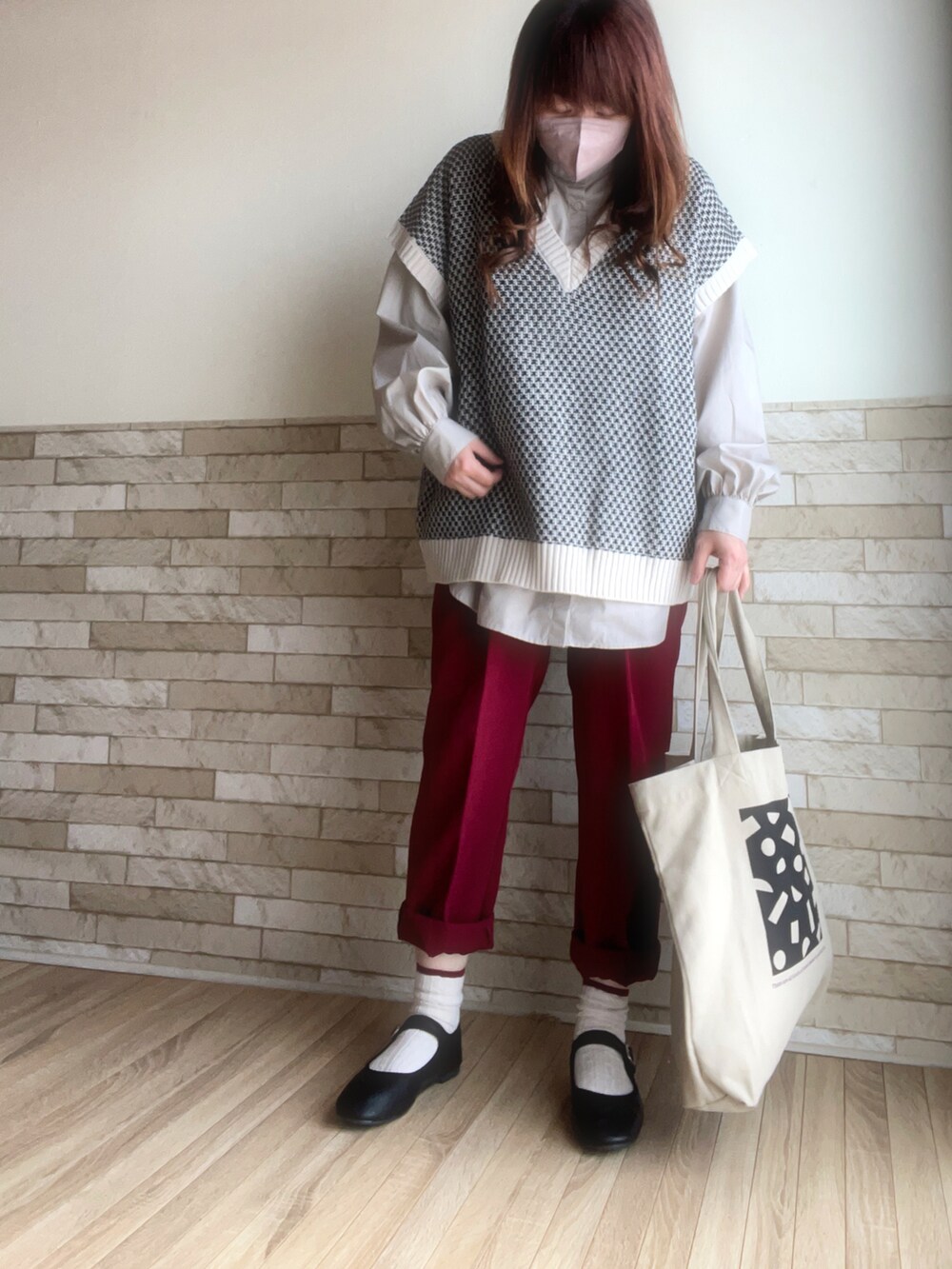 ベージュ系のシャツ/ブラウス、ホワイト系のベスト、レッド系のスラックスを着用したレディースの春コーディネートの3枚目の写真