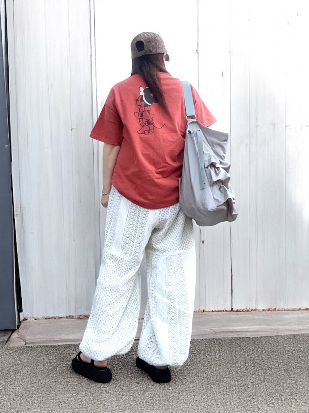 オレンジ系のTシャツ/カットソー、グレー系のショルダーバッグ、ホワイト系のその他パンツを着用したレディースの夏コーディネートの3枚目の写真