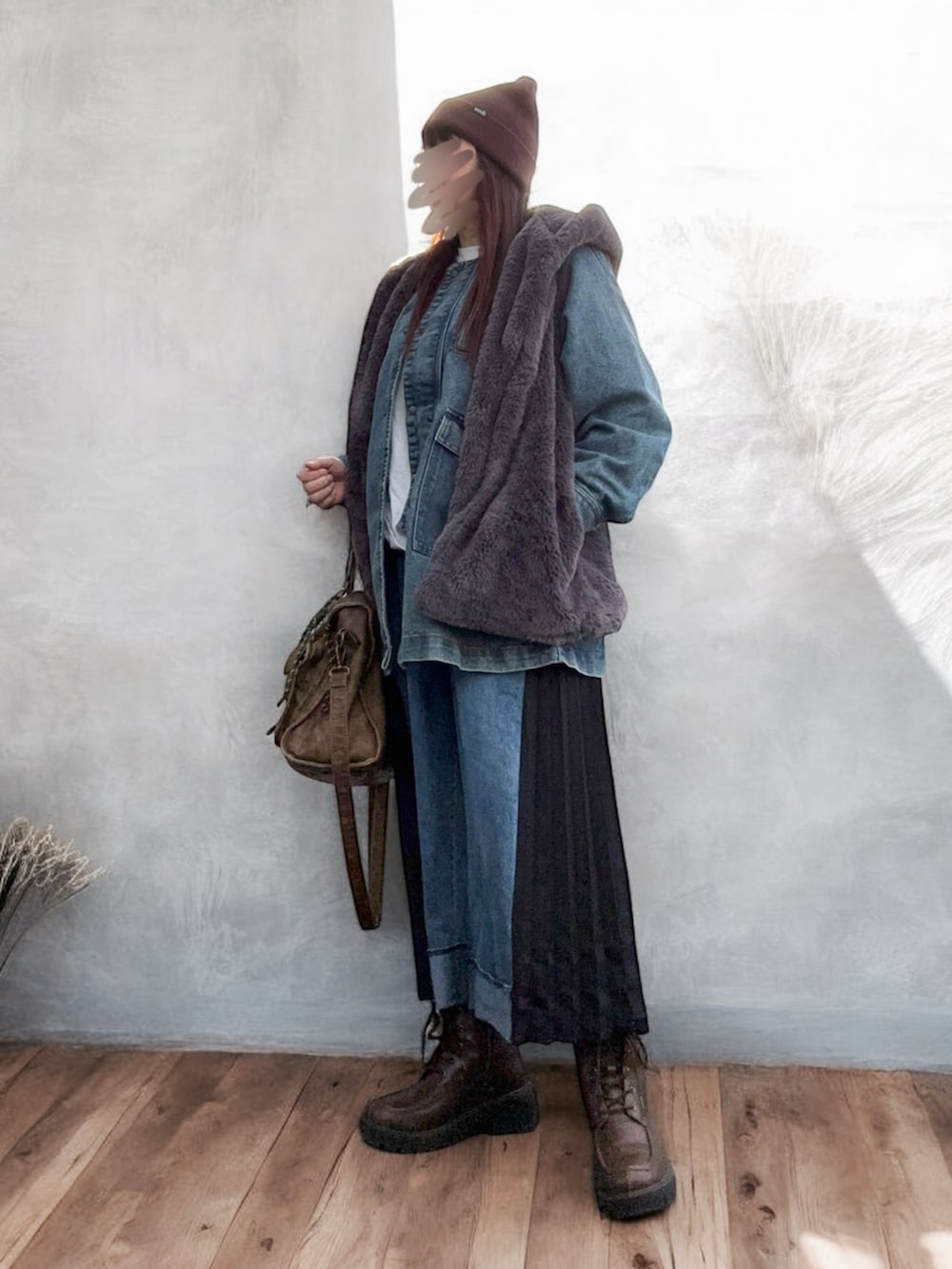 ブルー系のデニムジャケット、グレー系のベスト、ブルー系のデニムパンツを着用したレディースの秋コーディネートの2枚目の写真